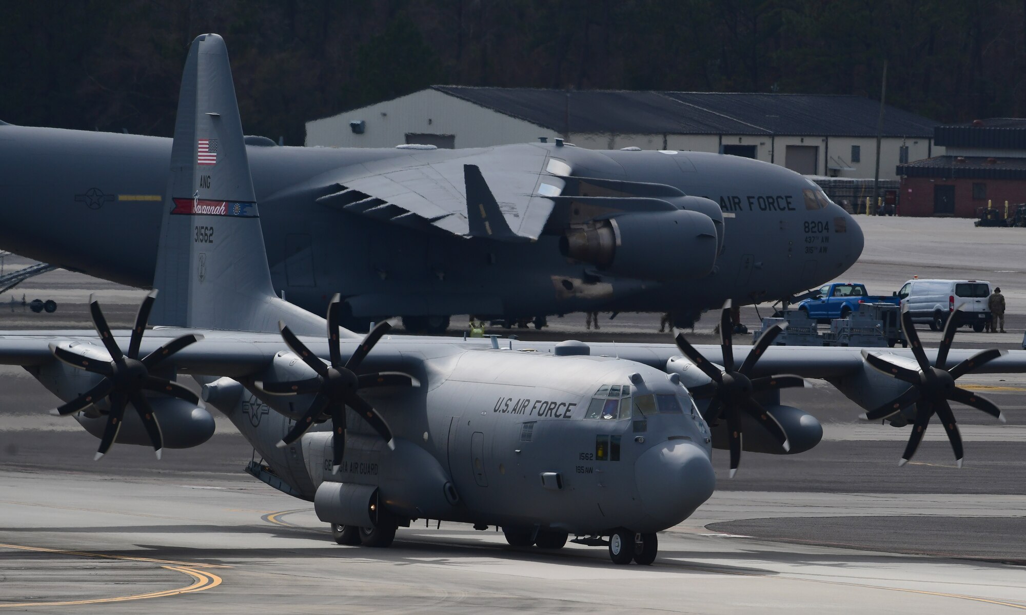 A photo of two planes on a flightline.