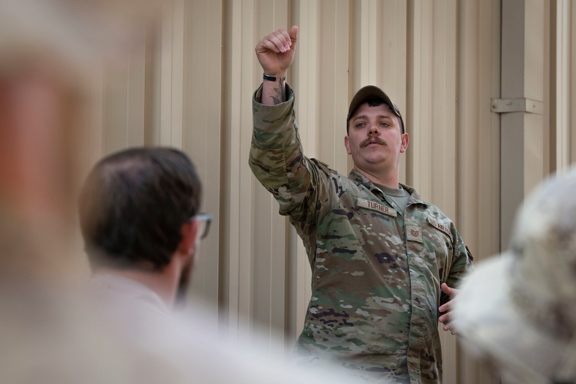 U.S. Air Force Tech. Sgt. Brendan Turner, 386th Expeditionary Security Forces Squadron kennel master, briefs a group of Canadian Armed Forces members before a Military Working Dog bite demonstration at Ali Al Salem Air Base, Kuwait, Feb. 16, 2023.