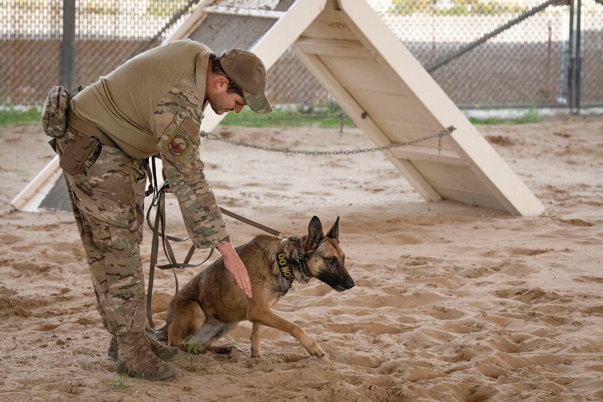 U.S. Air Force Senior Airman Sean Capan, 386th Expeditionary Security Forces Squadron Military Working Dog handler, signals for MWD Pepper to lay down during a MWD bite demonstration at Ali Al Salem Air Base, Kuwait, Feb. 16, 2023.