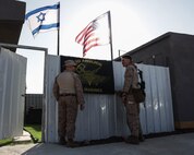 U.S. Marines with 3rd Air Naval Gunfire Liaison Company, U.S. Marine Corps Forces Reserve, hang up their unit flag during exercise Intrepid Maven 23.2, Feb. 19, 2023. Intrepid Maven is a bilateral exercise between USMARCENT and the IDF designed to improve interoperability, strengthen partner-nation relationships in the U.S. Central Command area of operations and improve both individual and bilateral unit readiness. (U.S. Marine Corps photo by Cpl. Kolby Leger)