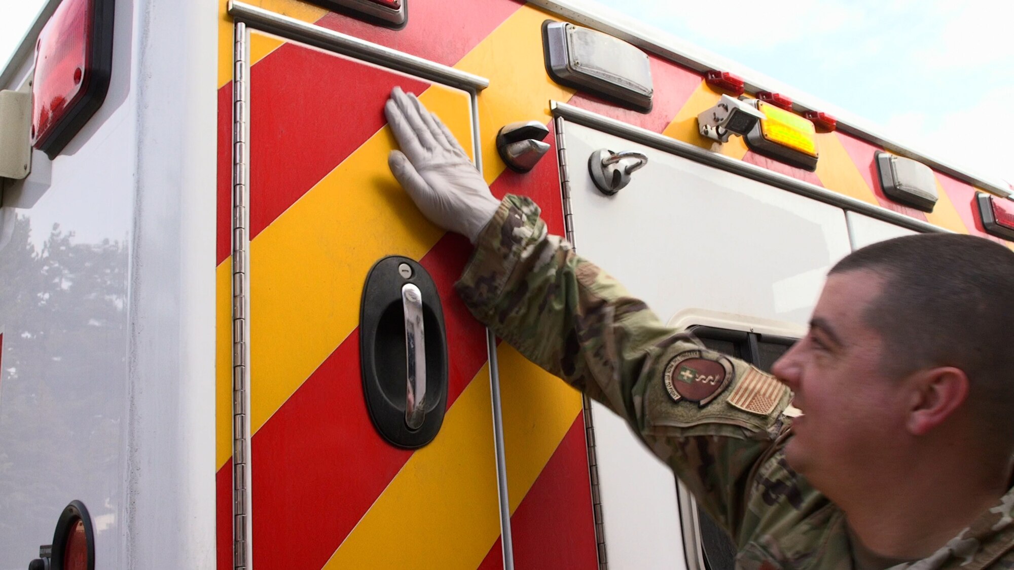 Staff Sgt. Nathan Wemhoff, 8th Medical Group NCO in charge of ambulance services, hits the back of an ambulance on Kunsan Air Base, Republic of Korea, Feb. 16, 2022. Hitting the back of a vehicle is an international ‘all-clear’ sign notifying the driver they are cleared to depart to the designated medical treatment facility. (U.S. Air Force photo by Tech. Sgt. Timothy Dischinat)