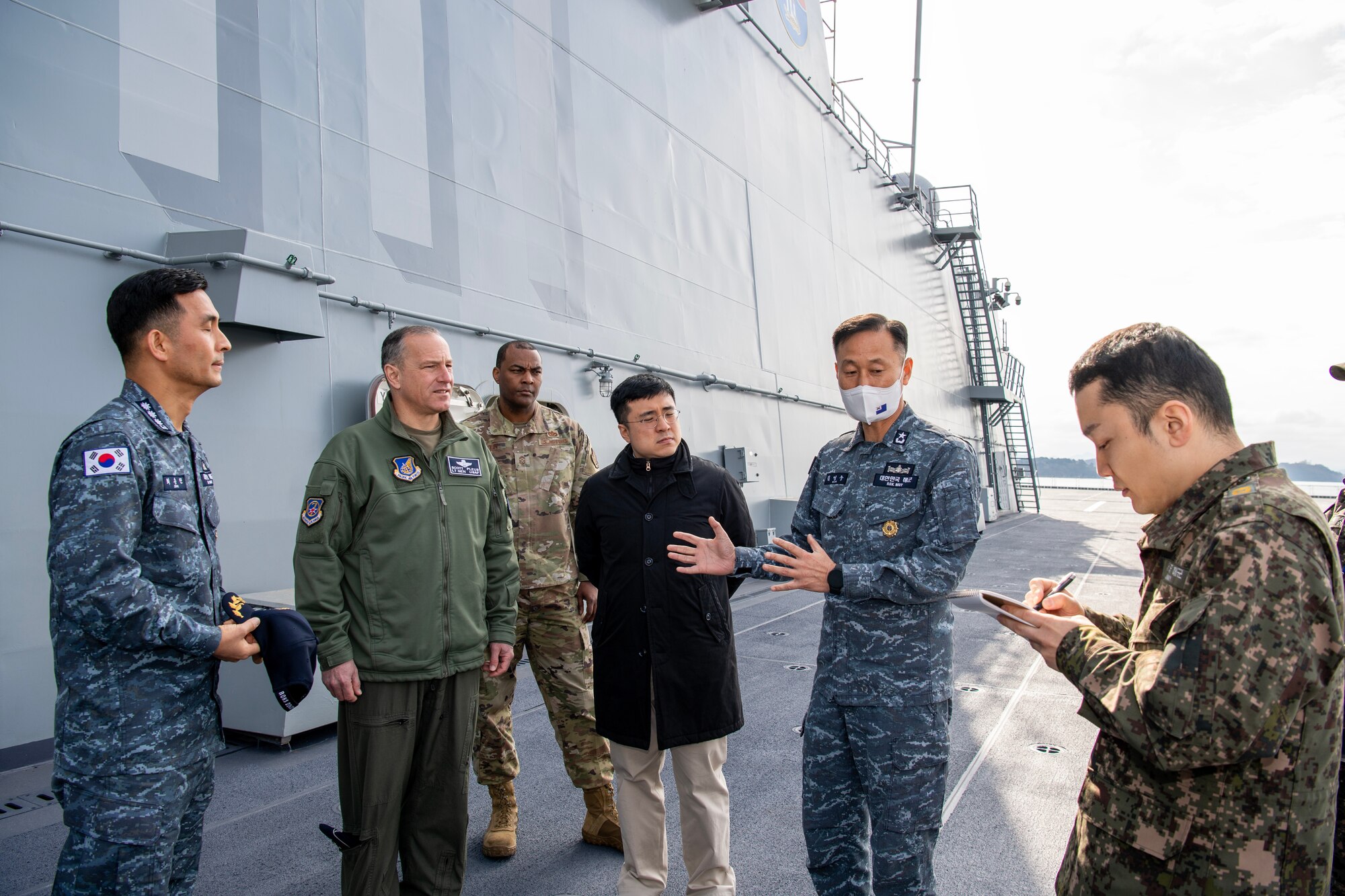 U.S. Air Force Lt. Gen. Scott Pleus, 7th Air Force commander (left) and U.S. Air Force Chief Master Sgt. Alvin Dyer, 7 AF command chief (middle), listen to Republic of Korea Navy Rear Adm. Young Soo Kim, during a tour of the Republic of Korea Ship Dokdo (LPH-6111), Feb. 15, 2023, in Jinhae, Republic of Korea