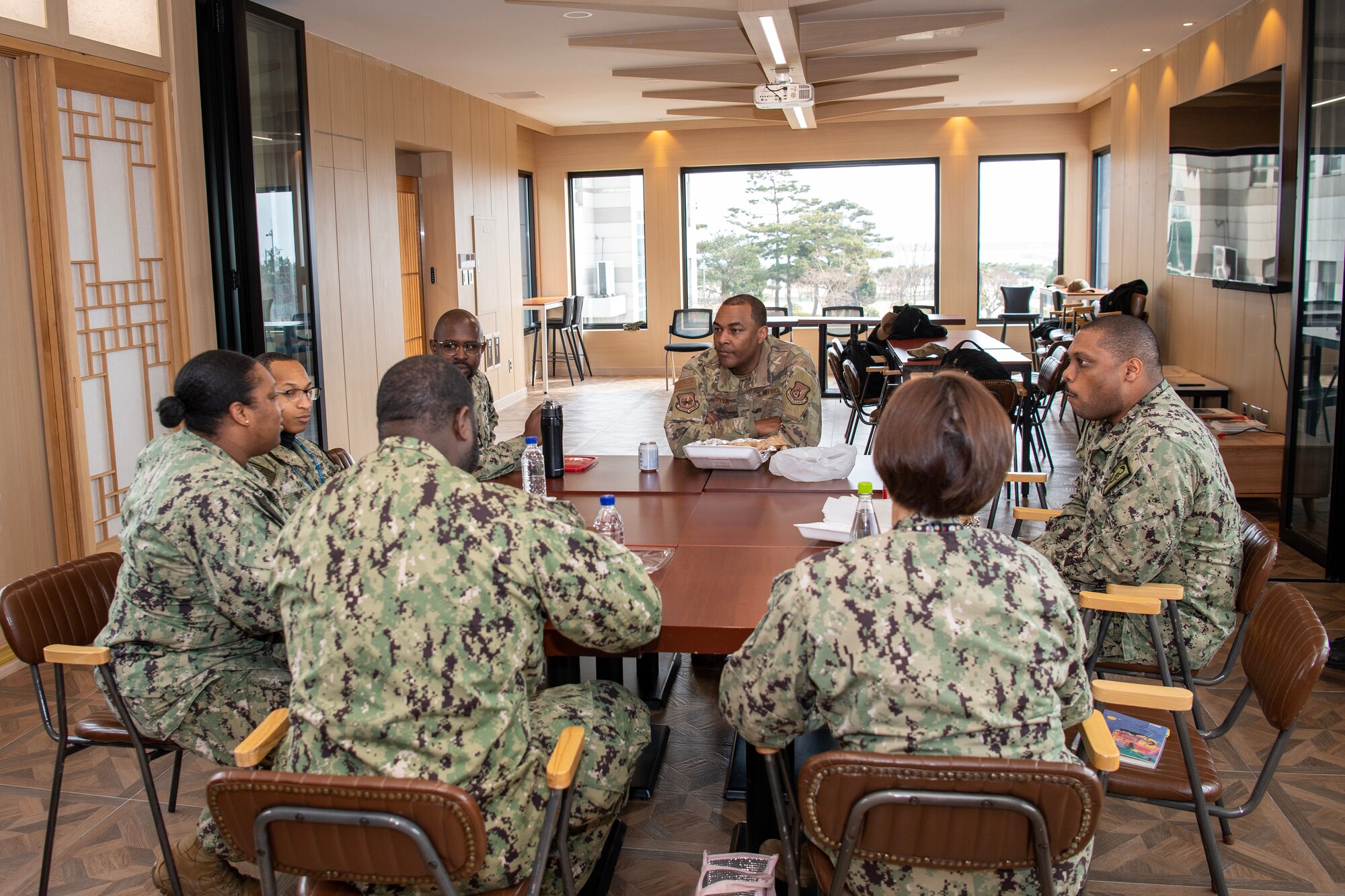 U.S. Air Force Chief Master Sgt. Alvin Dyer, 7 AF command chief (middle), talks to U.S. Navy senior non-commissioned officers assigned to U.S. Naval Forces Command Korea, during a visit, Feb. 15, 2023, in Busan, Republic of Korea.