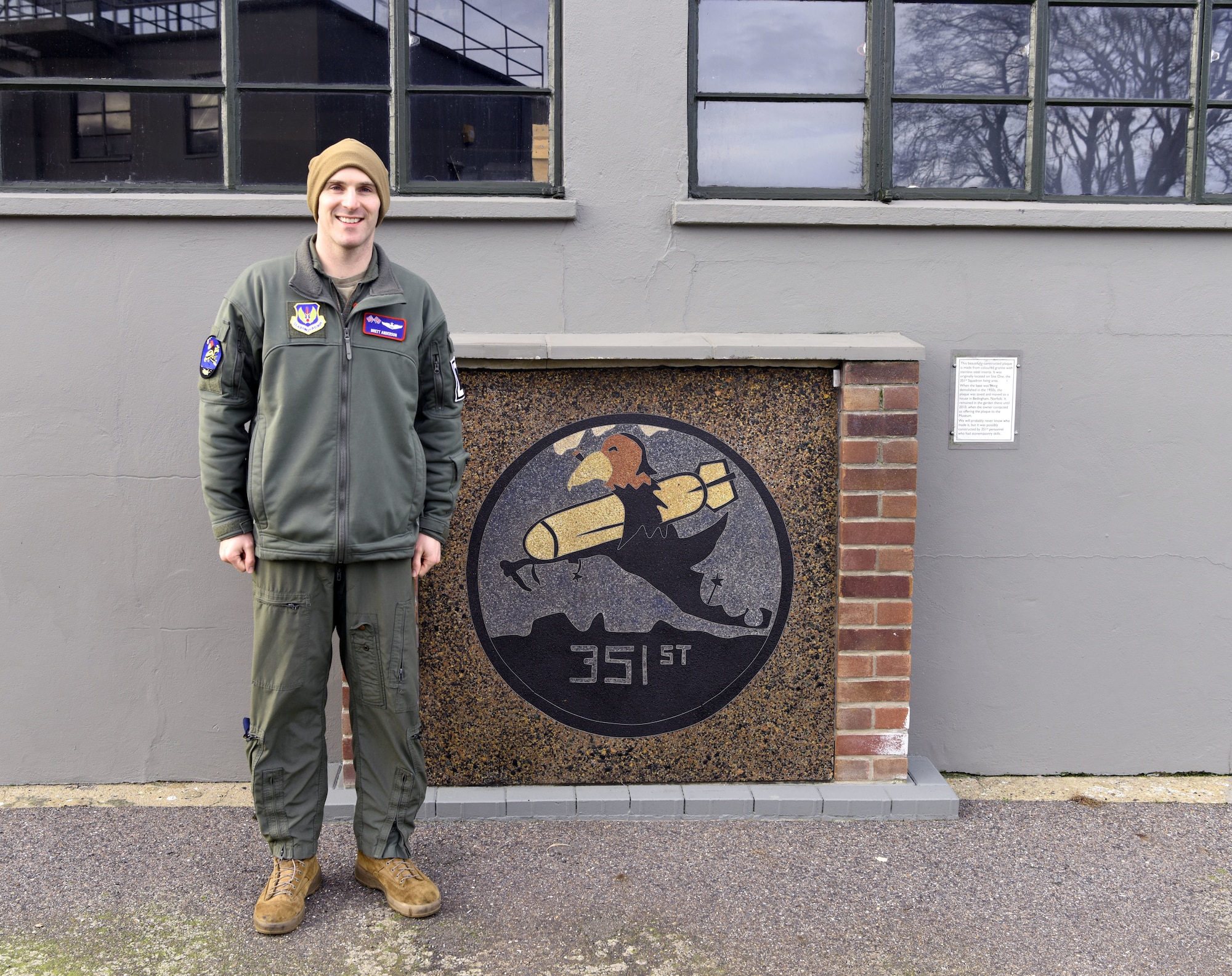 U.S. Air Force Capt. Brett Anderson, 351st Air Refueling Squadron KC-135 Stratotanker pilot and currently on loan to the 100th Operations Squadron, stands by a memorial heritage patch near the original control tower of the 351st Bomb Squadron and 100th Bomb Group Feb. 2, 2023, at the 100th BG Memorial Museum, Thorpe Abbotts, Diss, England. The 351st ARS at Royal Air Force Mildenhall is the third squadron Anderson has been assigned to, and all three – 351st ARS, 350th ARS and 350th ARS both at McConnell Air Force Base – are heritage squadrons from the 100th BG. (U.S. Air Force photo by Karen Abeyasekere)