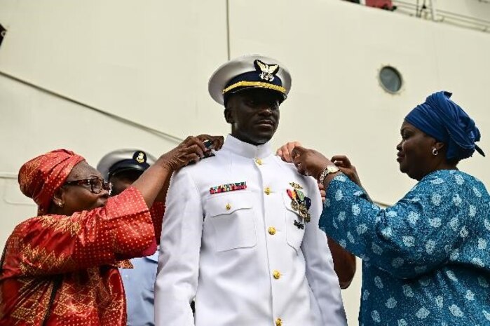 U.S. Coast Guard Ensign Mohammad Diakite, middle, assigned to USCGC Spencer (WMEC 905), is pinned by Chief Petty Officer Andrae Coulter, left, and Petty Officer 1st Class Frederick Garza during his promotion ceremony in Abidjan, Côte d’Ivoire, Feb. 19, 2023.