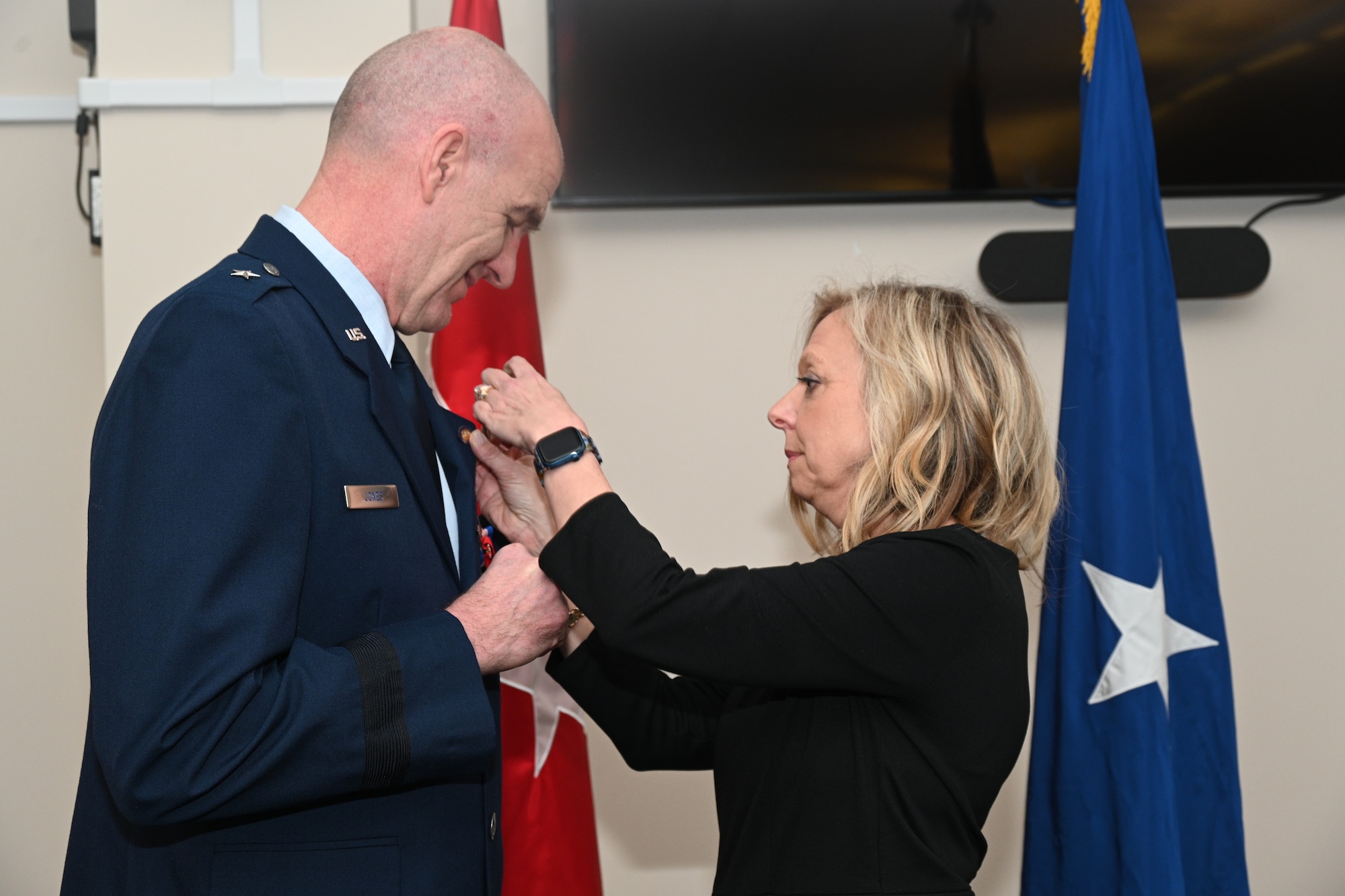 U.S. Air Force Brig. Gen. Edward Jones, assistant adjutant general-air, Maryland National Guard, is presented with the retirement pin by his wife Cindy Jones, Feb. 11, 2023, at Warfield Air National Guard Base at Martin State Airport, Middle River, Maryland, during his retirement ceremony.