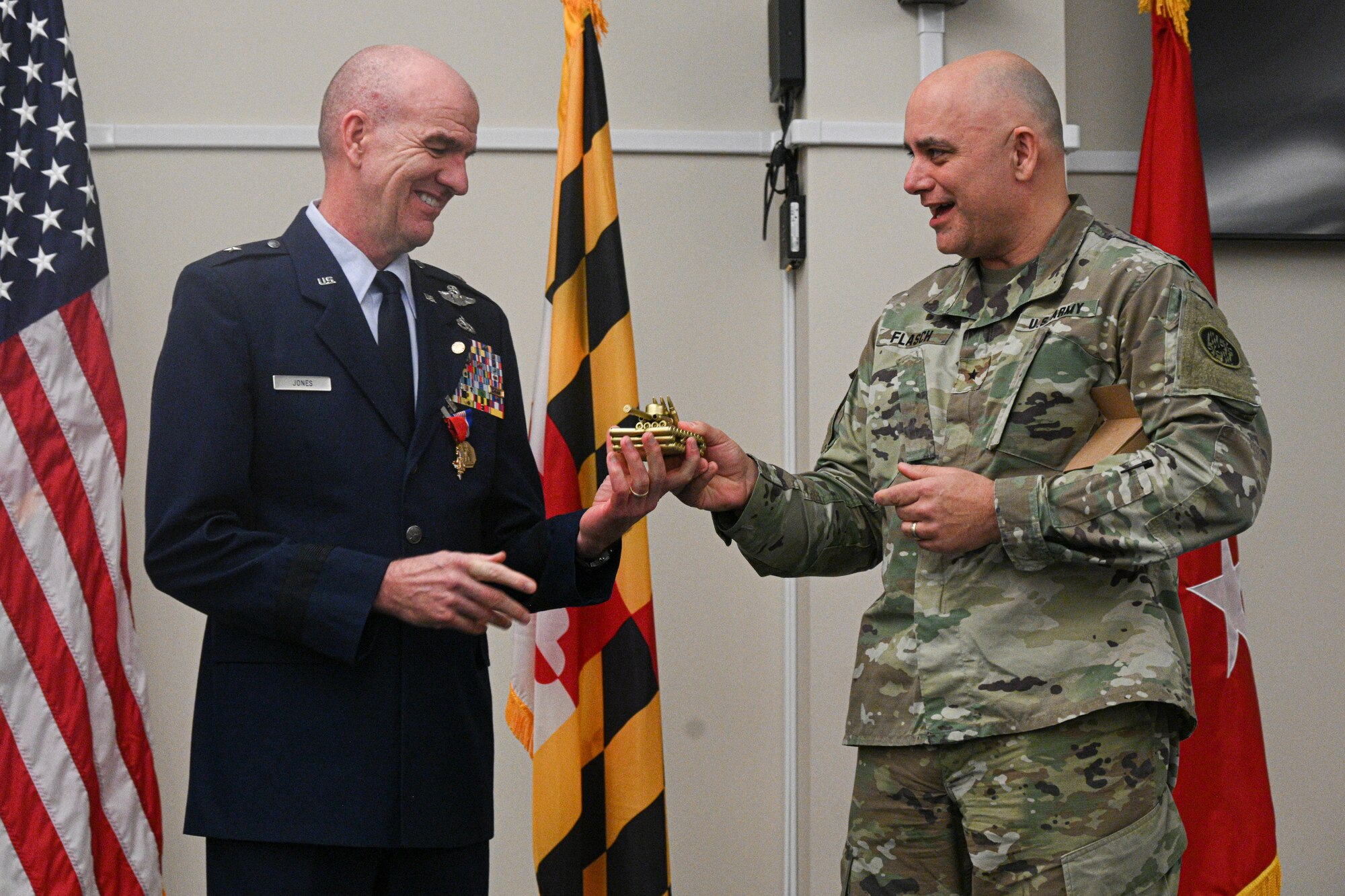 U.S. Air Force Brig. Gen. Edward Jones, assistant adjutant general-air, Maryland National Guard, is gifted with a tank crafted out of bullets by Brig. Gen. Adam R. Flasch, director of joint staff, Maryland, Feb. 11, 2023, at Warfield Air National Guard Base at Martin State Airport, Middle River, Maryland, during the retirement ceremony for Jones.
