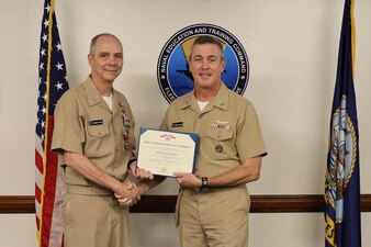 Rear Adm. Pete Garvin, right, commander, Naval Education and Training Command (NETC), presents the Legion of Merit to Force Master Chief Matthew Harris, NETC’s off-going force master chief, during a change of charge ceremony at NETC headquarters onboard Naval Air Station Pensacola, February 16, 2023. NETC’s mission is to recruit, train and deliver those who serve our nation, taking them from street-to-fleet by transforming civilians into highly skilled, operational and combat ready warfighters. (United States Navy photo by Lt. j.g. Sean Panish)