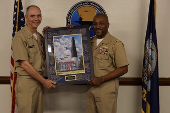 Capt. Cliff Collins, right, Naval Education and Training Command’s (NETC) chief of staff, presents Force Master Chief Matthew Harris, NETC’s off-going force master chief, with a token of appreciation after a change of charge ceremony at NETC headquarters onboard Naval Air Station Pensacola, February 16, 2023. NETC’s mission is to recruit, train and deliver those who serve our nation, taking them from street-to-fleet by transforming civilians into highly skilled, operational and combat ready warfighters. (United States Navy photo by Lt. j.g. Sean Panish)