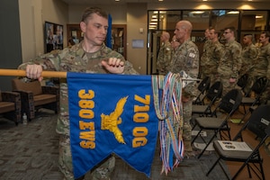 An individual unfurls a flag.