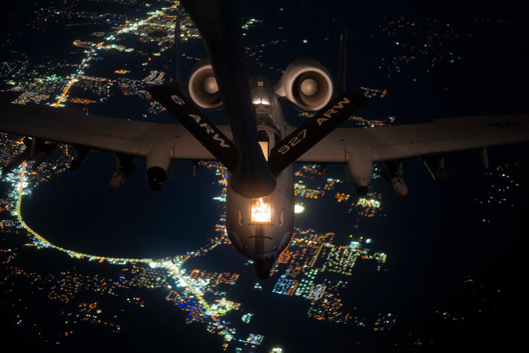 An aircraft receives fuel midair at night.