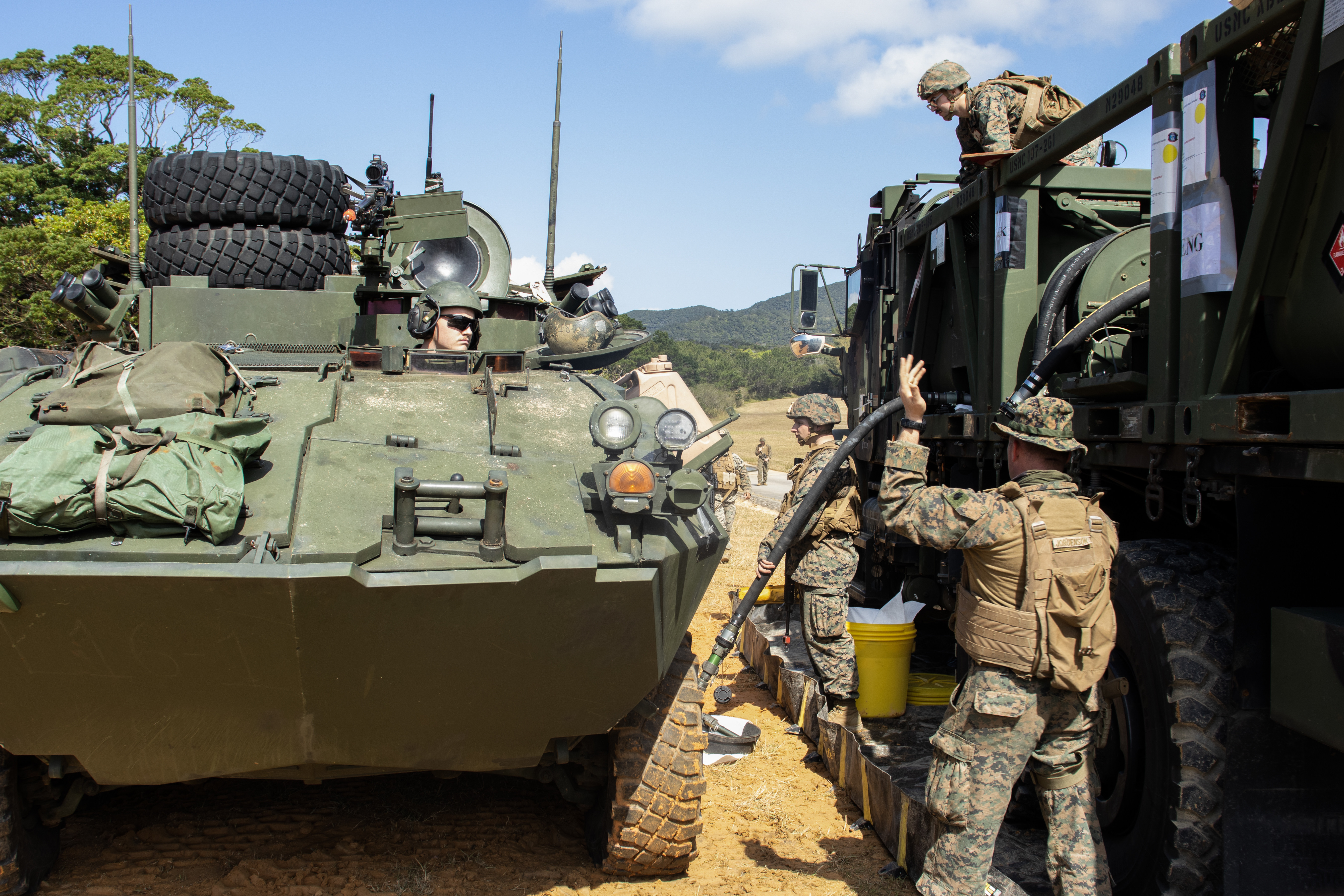 U.S. Marines with Combat Logistics Battalion 31, 31st Marine Expeditionary Unit, fuel a light armored vehicle, operated by Marines with Battalion Landing Team 1/4, 31st MEU, during a combat service support area exercise on Camp Hansen, Okinawa, Japan, Feb. 8, 2023. A CSSA provides Marines on the ground with food, water, and fuel to support the mission and sustain an area of operations. The 31st MEU is operating aboard ships of USS America Amphibious Ready Group in the 7th fleet area of operations to enhance interoperability with allies and partners and serve as a ready response force to defend peace and stability in the Indo-Pacific region. (U.S. Marine Corps photo by Cpl. Christopher R. Lape)