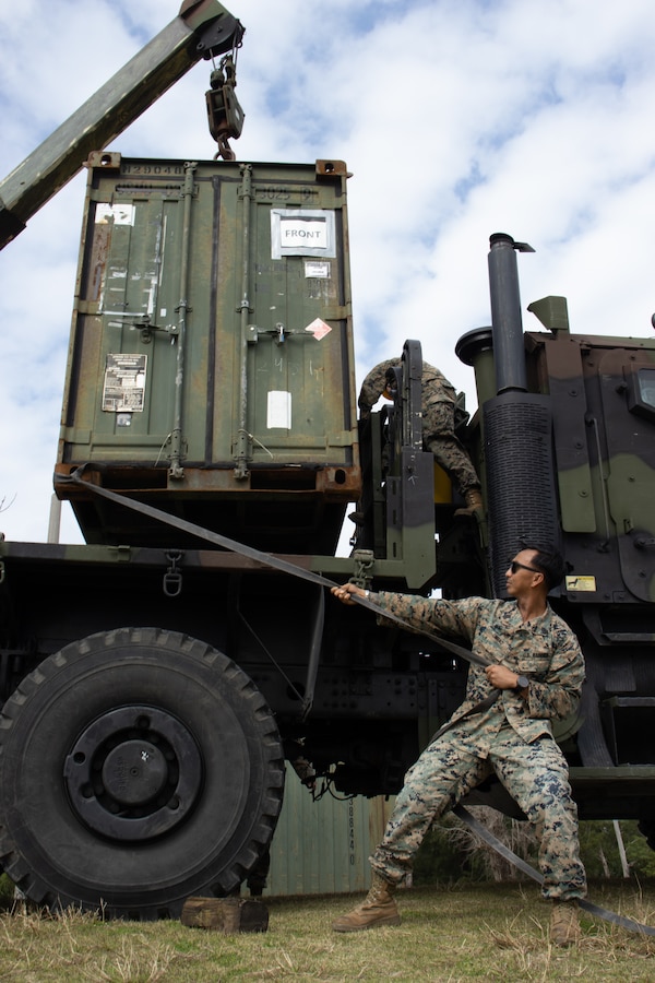 U.S. Marine Corps Gunnery Sgt. Jeric Ombao, the motor transport maintenance chief of Combat Logistics Battalion 31, with 31st Marine Expeditionary Unit, guides a quadcon into position during a combat service support area exercise at Kin Blue, Okinawa, Japan, Feb. 9, 2023. A CSSA provides Marines on the ground with food, water, and fuel to support the mission and sustain an area of operations. The 31st MEU is operating aboard ships of USS America Amphibious Ready Group in the 7th fleet area of operations to enhance interoperability with allies and partners and serve as a ready response force to defend peace and stability in the Indo-Pacific region. (U.S. Marine Corps photo by Cpl. Christopher R. Lape)