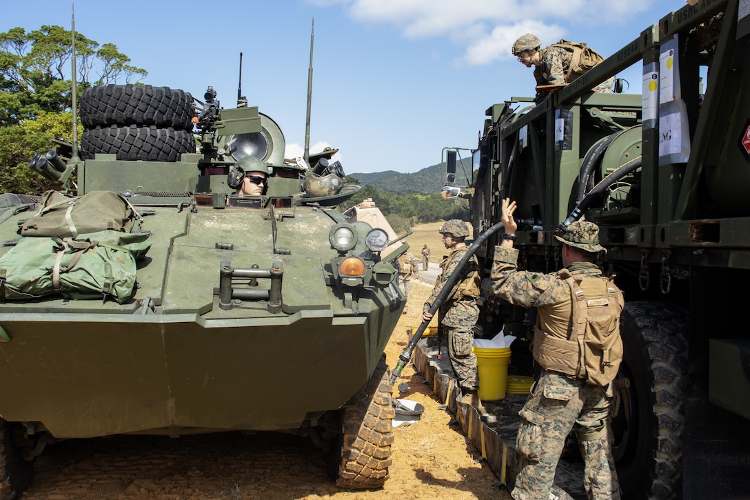 U.S. Marines with Combat Logistics Battalion 31, 31st Marine Expeditionary Unit, fuel a light armored vehicle, operated by Marines with Battalion Landing Team 1/4, 31st MEU, during a combat service support area exercise on Camp Hansen, Okinawa, Japan, Feb. 8, 2023. A CSSA provides Marines on the ground with food, water, and fuel to support the mission and sustain an area of operations. The 31st MEU is operating aboard ships of USS America Amphibious Ready Group in the 7th fleet area of operations to enhance interoperability with allies and partners and serve as a ready response force to defend peace and stability in the Indo-Pacific region. (U.S. Marine Corps photo by Cpl. Christopher R. Lape)