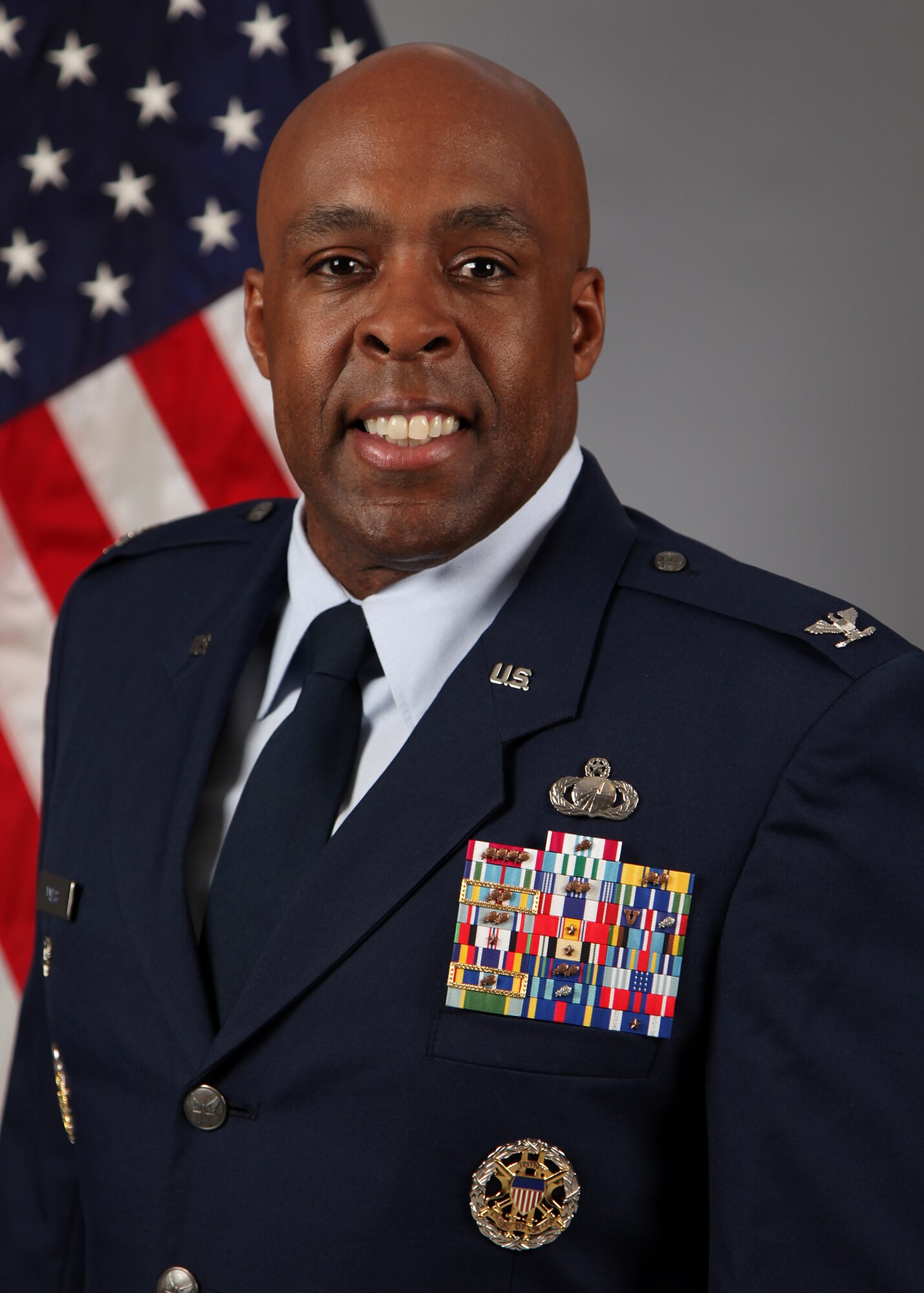 Man in dress uniform in front of a U.S. flag