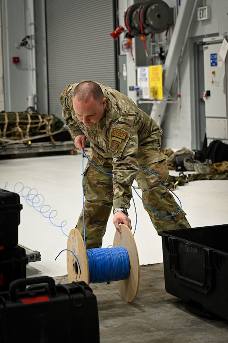 An Airman unravels communication wire