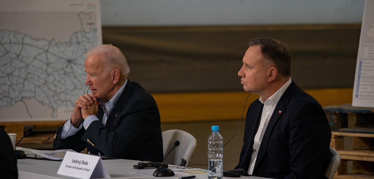 Two men listen to a briefing.