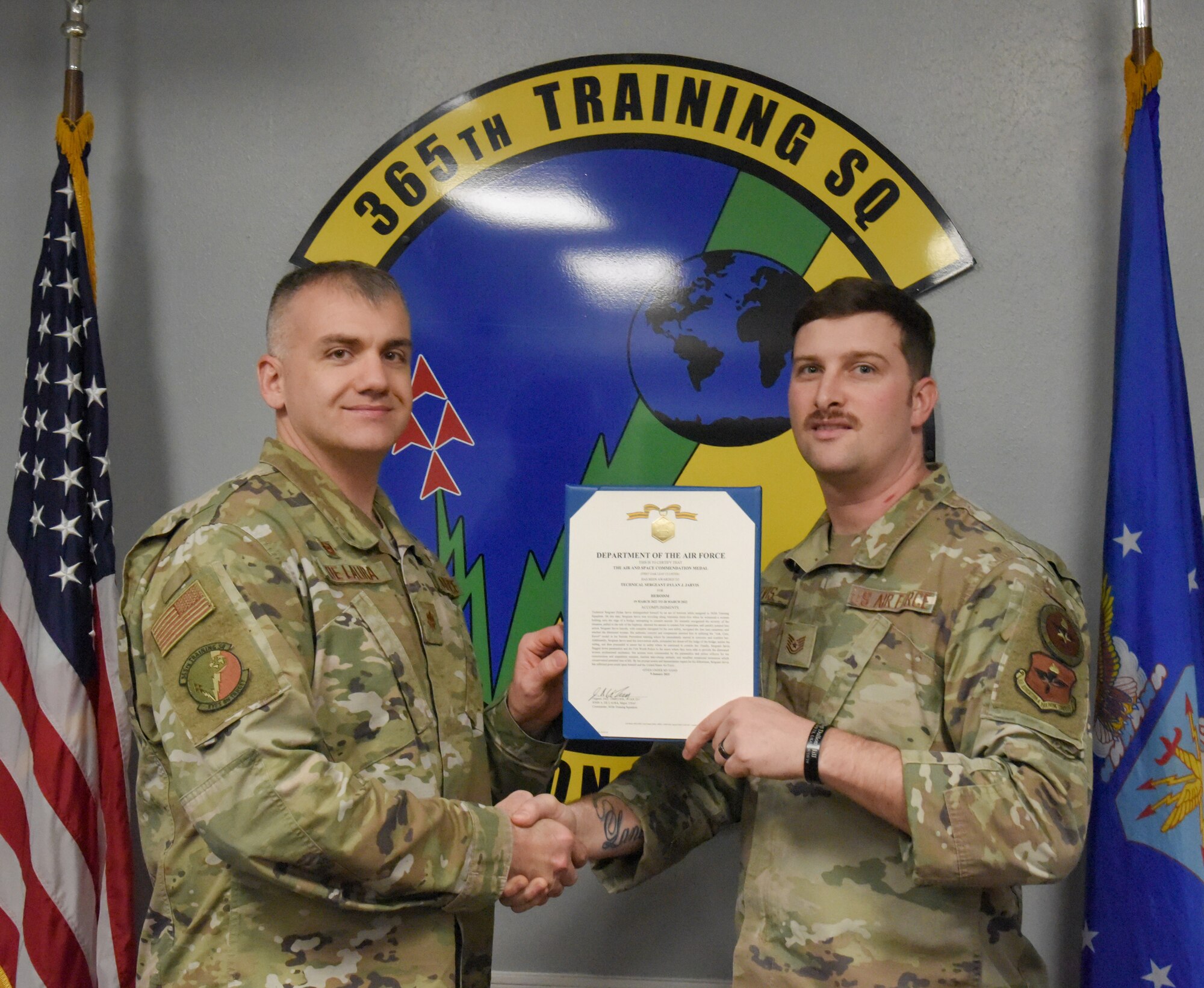 Maj. John De Laura, Commander of the 365th Training Squadron, presents the Air and Space Commendation Medal to Tech. Sgt. Dylan Jarvis, 365th TRS instructor supervisor.