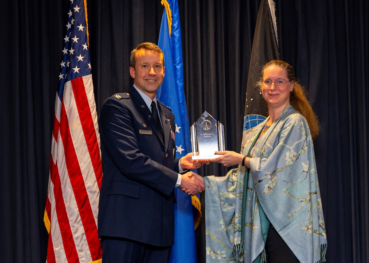 Col. Jeremy Raley, director of the Air Force Research Laboratory, or AFRL, Space Vehicles Directorate presents Dr. Madeleine Naudeau, a senior physicist with the Scientific and Technical Management Award at the directorate’s 2022 annual awards ceremony Feb. 8, 2023, at Kirtland Air Force Base, New Mexico. Naudeau was recognized for her leadership as the AFRL space communications and position, navigation and timing program manager. Naudeau led teams for two on-orbit and four pending flight experiments to develop advanced GPS and military satellite communication capabilities for customers, partners and operational users.