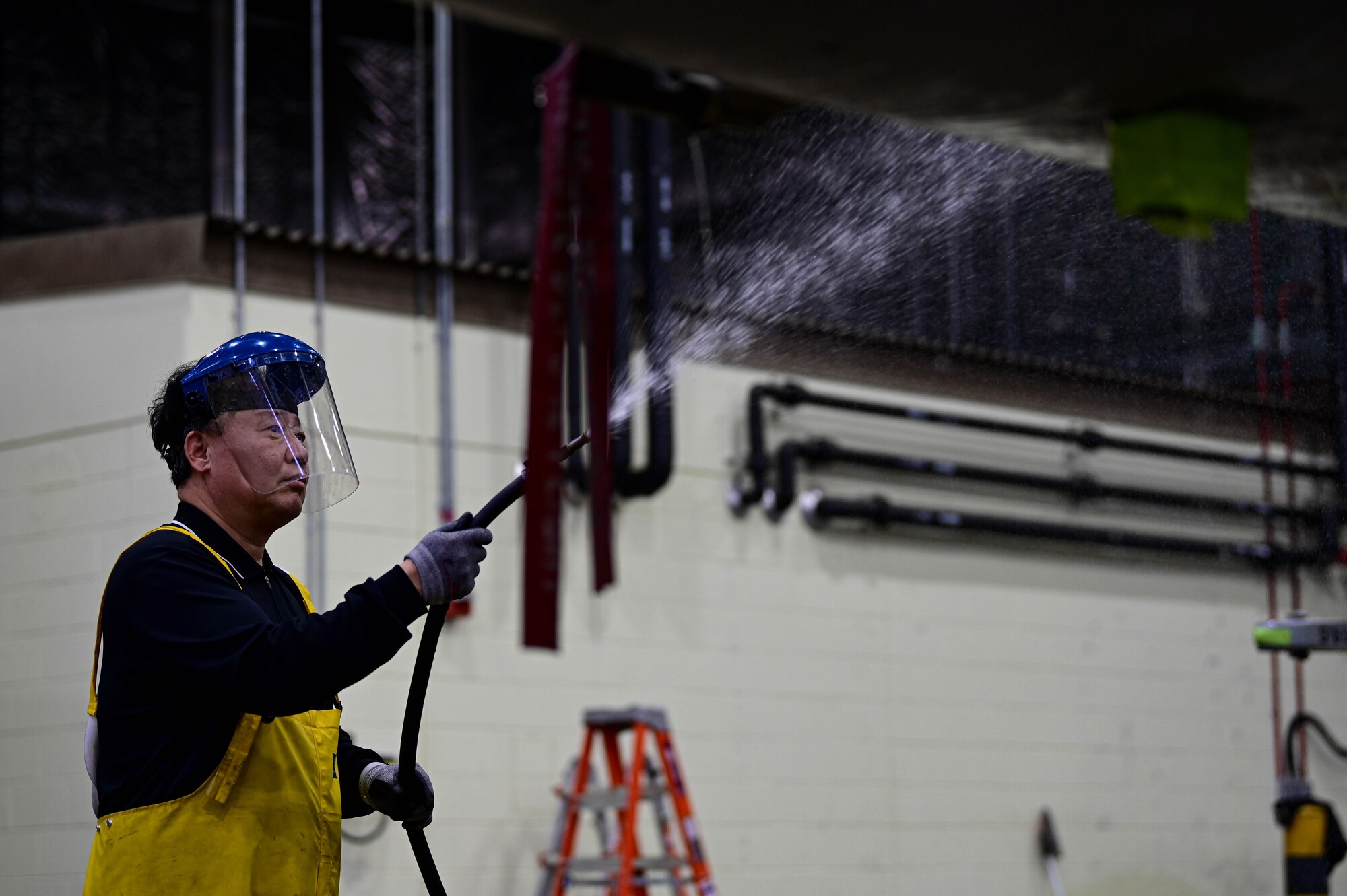Kyong Taek Cho, 8th Maintenance Squadron corrosion control section aircraft painter, sprays water on an F-16 Fighting Falcon at Kunsan Air Base, Republic of Korea, Feb. 17, 2023.
