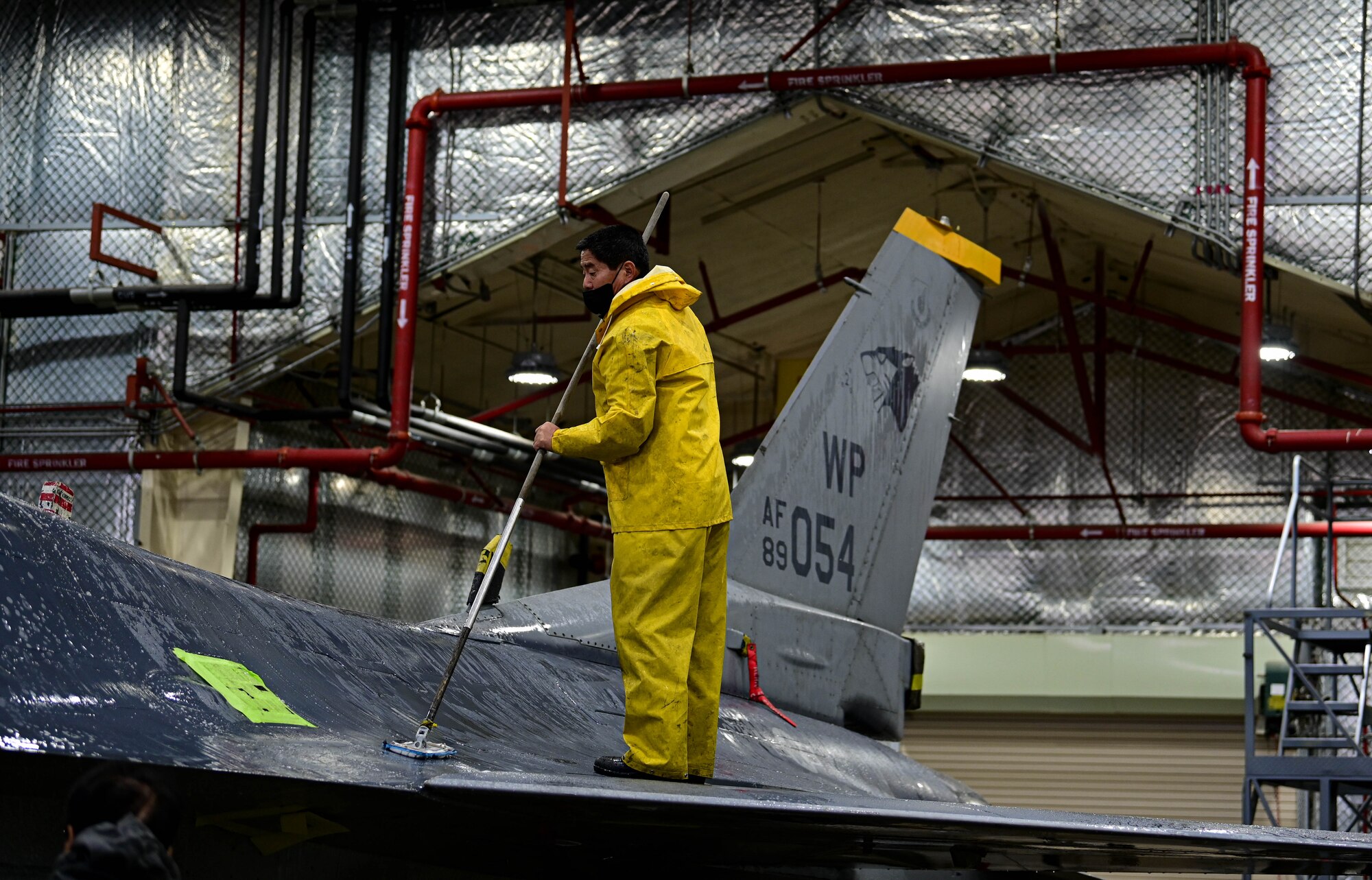 Huan Dok Chang, 8th Maintenance Squadron corrosion control section aircraft painter, scrubs the wing of an F-16 Fighting Falcon at Kunsan Air Base, Republic of Korea, Feb. 17, 2023.