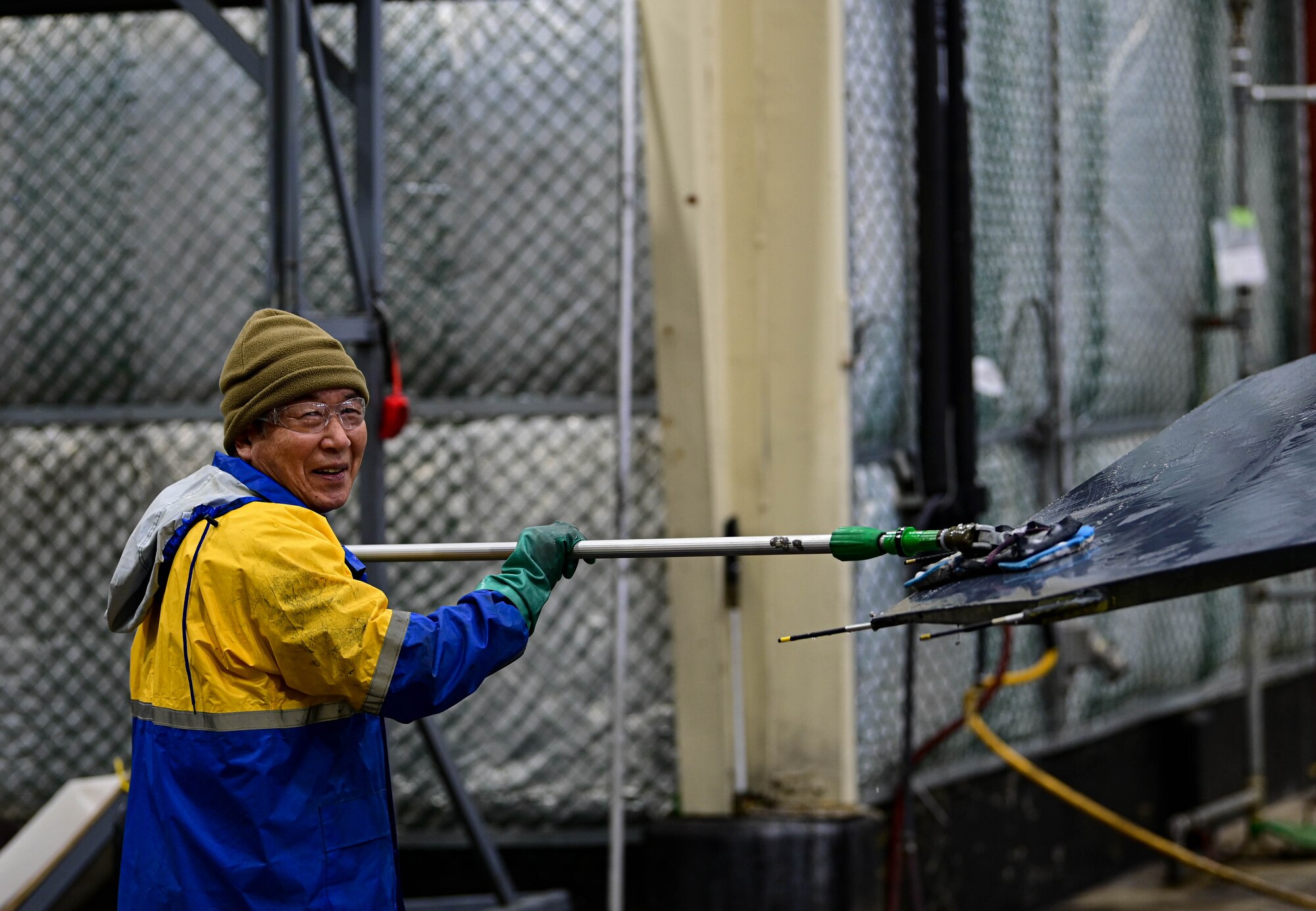 Kye Man Son, 8th Maintenance Squadron corrosion control section aircraft painter, laughs while scrubbing an F-16 Fighting Falcon at Kunsan Air Base, Republic of Korea, Feb. 17, 2023.