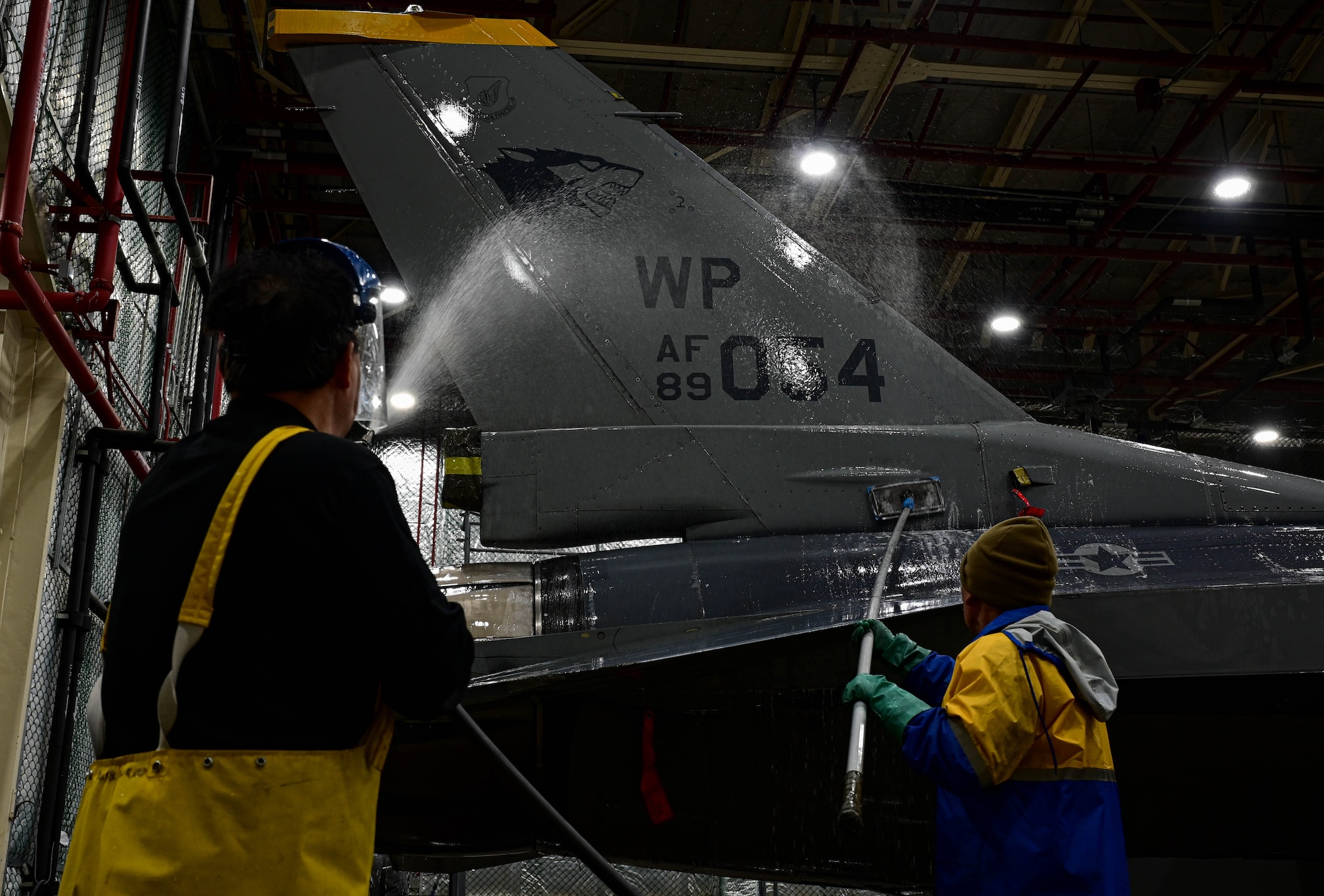 Kyong Taek Cho (left), 8th Maintenance Squadron corrosion control section aircraft painter and Kye Man Son (right), 8th Maintenance Squadron corrosion control section aircraft painter, wash an F-16 Fighting Falcon at Kunsan Air Base, Republic of Korea, Feb. 17, 2023.