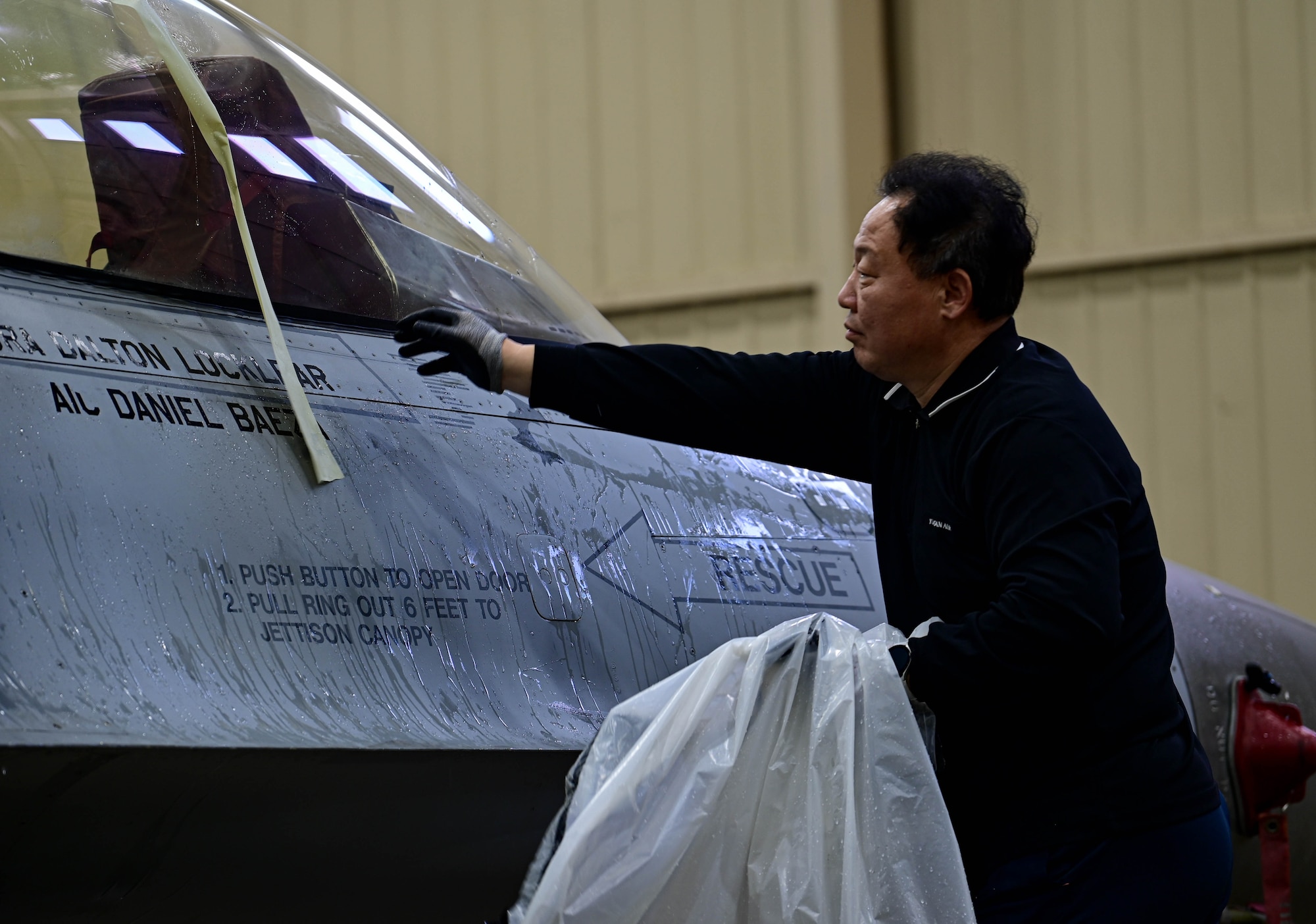 Kyong Taek Cho, 8th Maintenance Squadron corrosion control section aircraft painter, removes protective tape and coverings from an F-16 Fighting Falcon at Kunsan Air Base, Republic of Korea, Feb. 17, 2023.