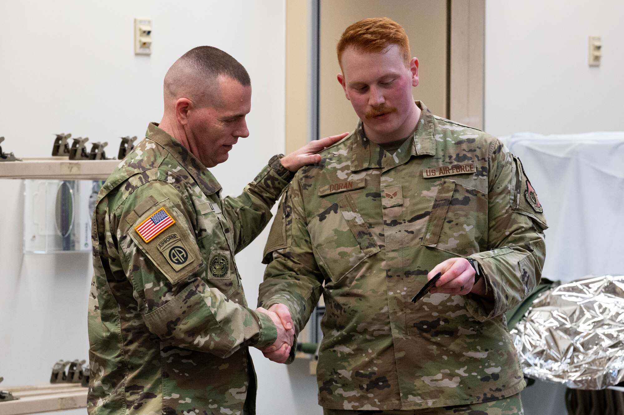 Army Command Sgt. Maj. Jack Love, U.S. Forces Korea Senior Enlisted Advisor, receives a 51st Medical Group (MDG) Patch from U.S. Air Force Senior Airman Johnathan Doran, 51st MDG flight and operational medicine technician during his visit at Osan Air Base, Republic of Korea, Feb. 16, 2023.