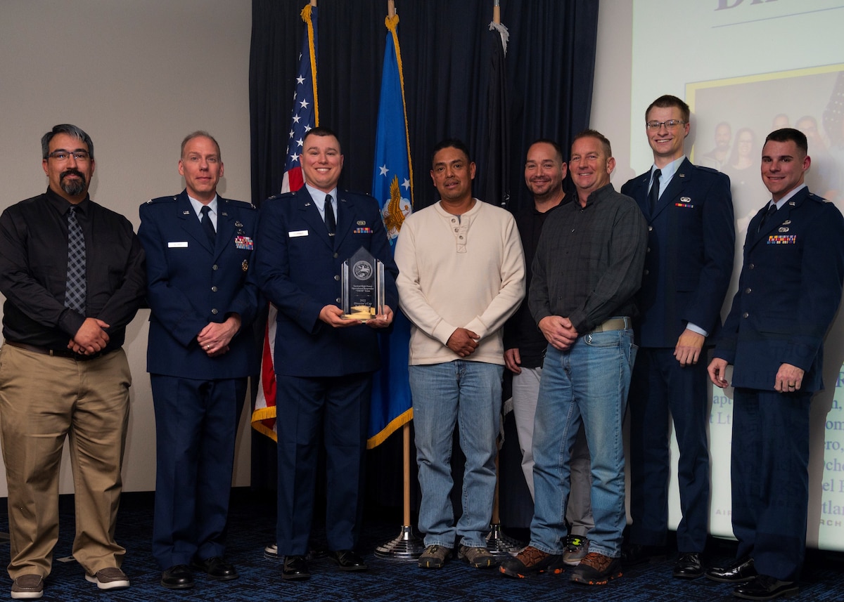 Col. Clark Allred, acting director of the Air Force Research Laboratory, or AFRL, Directed Energy Directorate, second from left, shares a photo with the AFRL Tactical High Power Operational Responder, or THOR, team following Allred’s presentation of the Director’s Cup R. Earl Good Team Award to the THOR team at the Directed Energy 2022 Annual Awards ceremony Feb. 9, 2023, at Kirtland Air Force Base, New Mexico. THOR is a counter-swarm electromagnetic weapon AFRL developed for defense of airbases to counter the threat of drones.