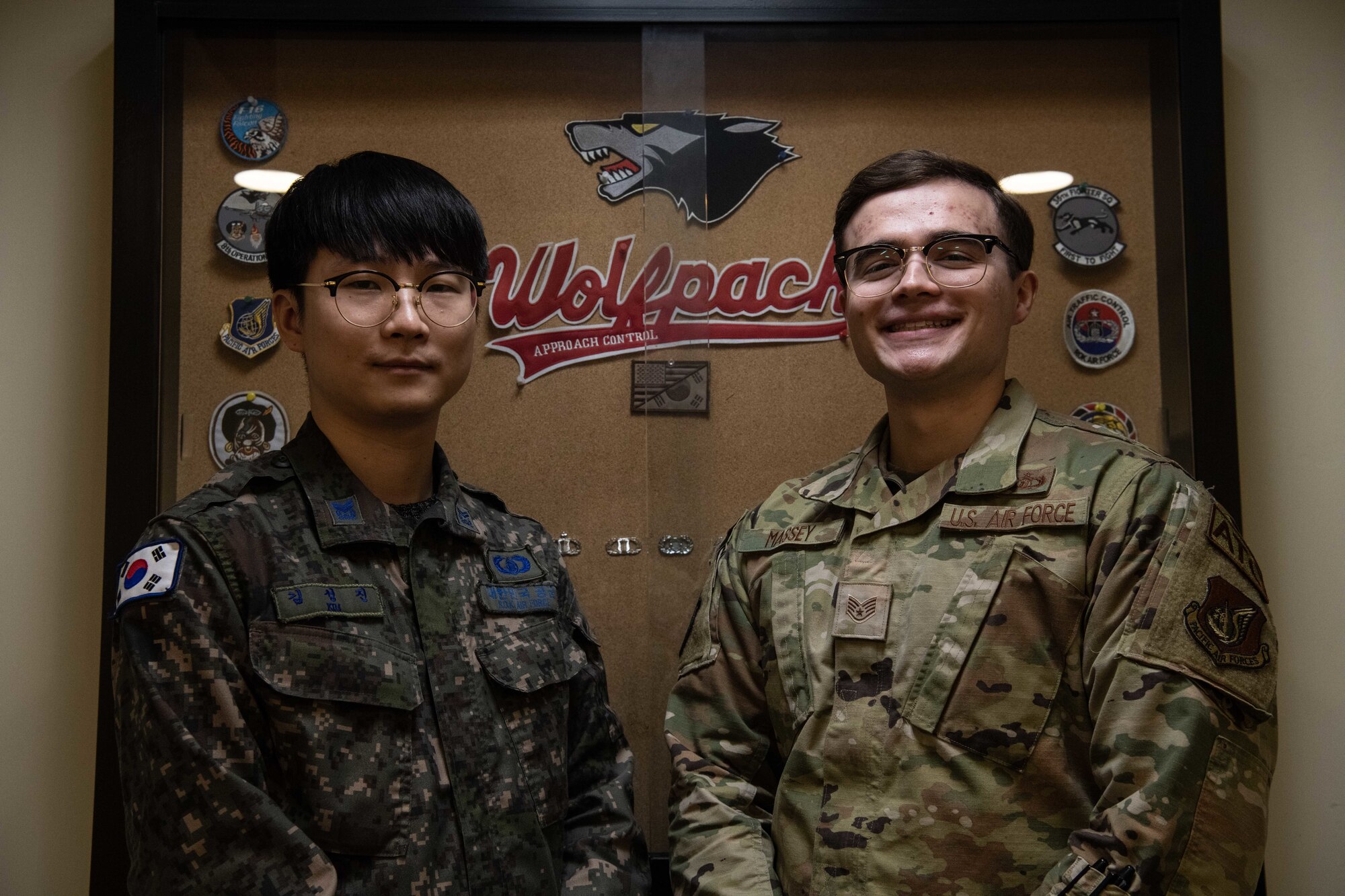 Republic of Korea Air Force Master Sgt. Seong Jin Kim (left), 38th Fighter Group operating branch radar controller, and U.S. Air Force Staff. Sgt. James Massey II, 8th Operations Support Squadron air traffic control radar approach controller watch supervisor, stand for a photo at Kunsan Air Base, Republic of Korea, Feb. 16, 2023. The team considered their partnership indispensable and couldn’t function as efficiently without their team’s backing. (U.S. Air Force photo by Staff Sgt. Sadie Colbert)