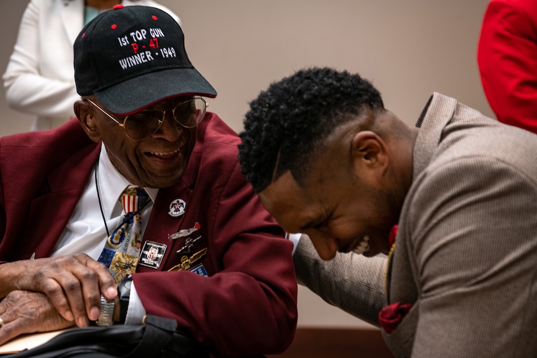 A Tuskegee Airman shares a laugh with another airman.