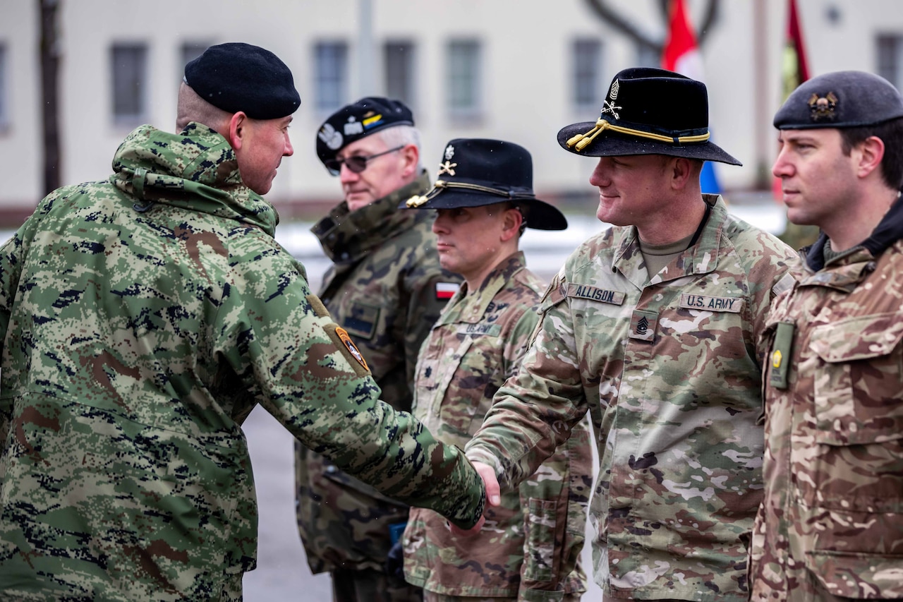 A military officer shakes hands with another officer during a ceremony.