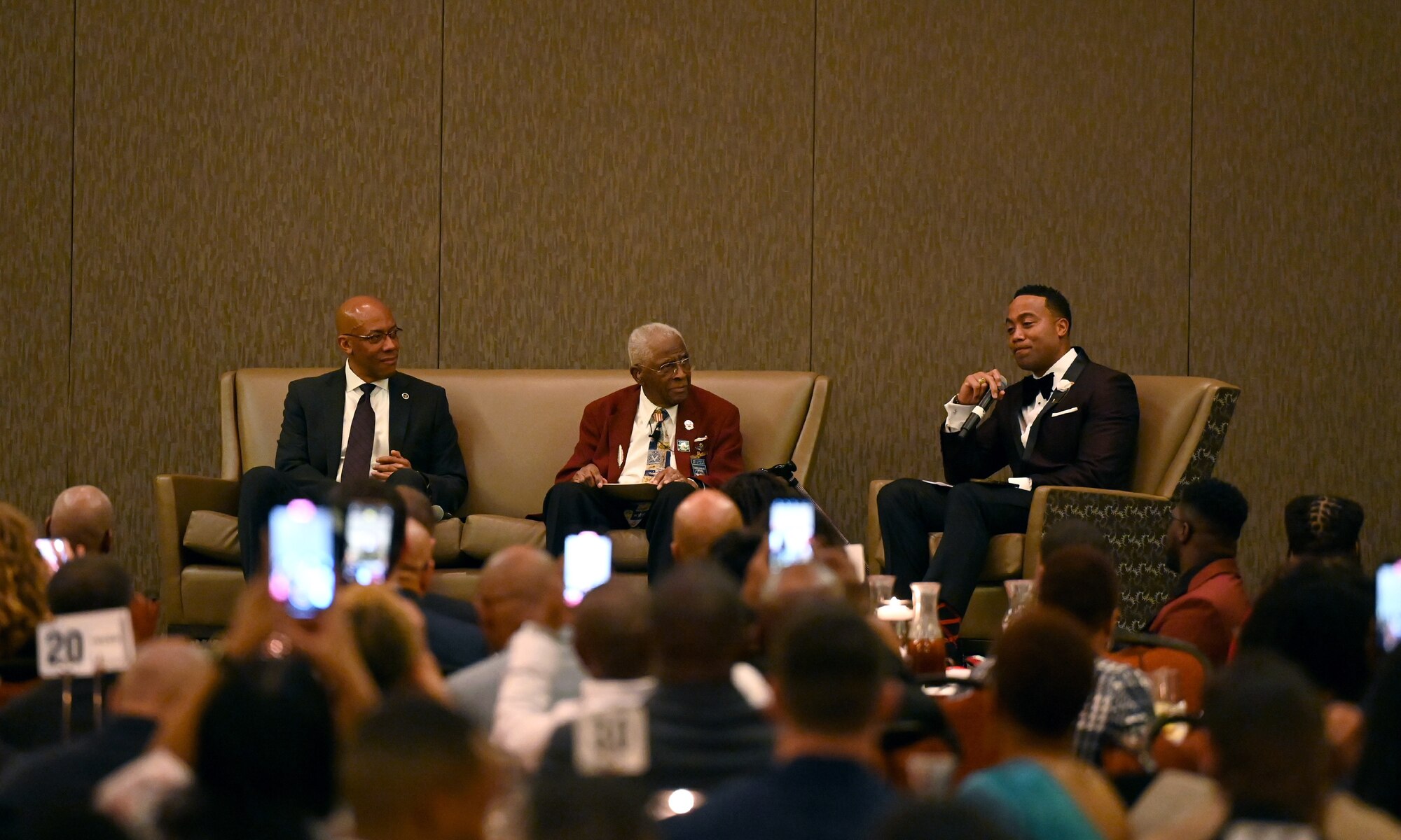 From left, U.S. Air Force Gen. CQ Brown, Jr., Air Force Chief of Staff, retired Lt. Col. James H. Harvey, an original Tuskegee Airman, and Maj. Saj El-Amin, Accelerating the Legacy moderator, participate in a fireside chat during the Accelerating the Legacy 2023 banquet in Charleston, South Carolina, Feb. 16, 2023. Accelerating the Legacy is an aviation heritage event that honors the Tuskegee Airmen’s legacy, offers professional development and networking opportunities to Total Force Airmen, and aims to inspire the next generation of aviation professionals. (U.S. Air Force photo by Tech. Sgt. Alex Fox Echols III)