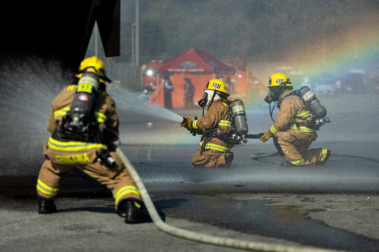 Firefighters with Marine Corps Installations Pacific Fire and Emergency Services, extinguish fire from a simulated aircraft during an air mishap exercise on Camp Hansen, Okinawa, Japan, Feb. 9, 2023.The bilateral training exercise tasked all participants with extinguishing an aircraft fire, retrieving all simulated casualties, and treating any injuries to bolster response plans for aircraft mishaps. U.S. Forces Japan and the Okinawa Defense Bureau coordinated the exercise with Provost Marshal’s Office, the Camp Hansen Camp Guard, MCIPAC, Fire and Emergency Services, surrounding area local fire departments, district police departments, and the U.S. Naval Hospital Okinawa. (U.S. Marine Corps photo by Lance Cpl. Thomas Sheng)