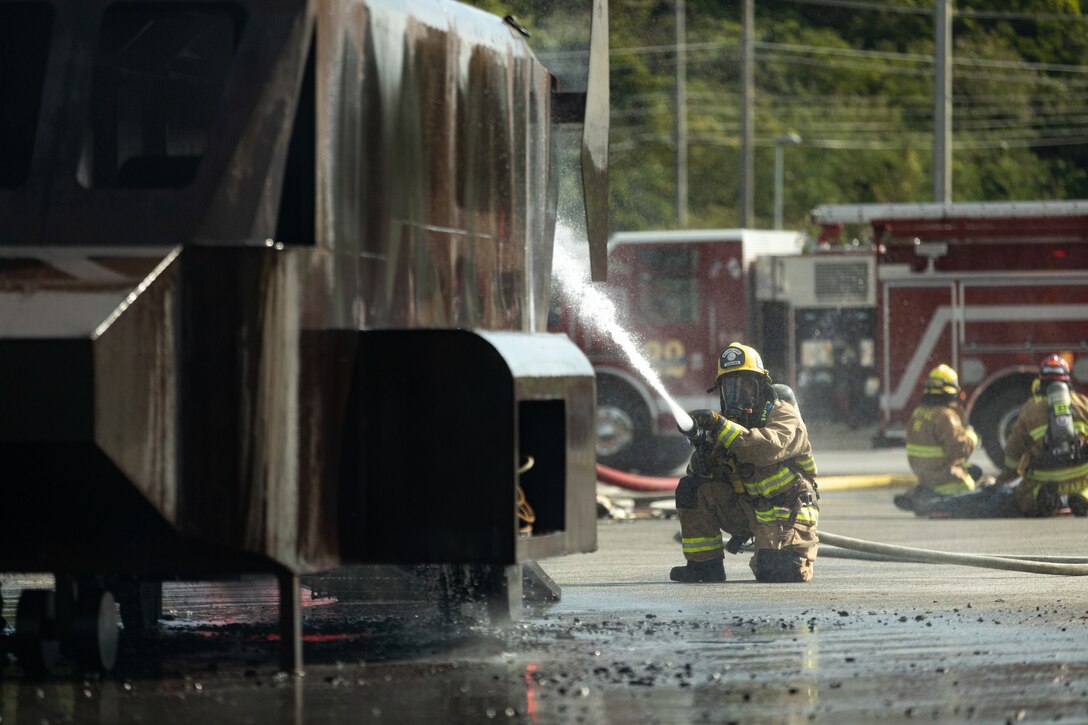 A firefighter with Marine Corps Installations Pacific Fire and Emergency Services, extinguishes a fire from a simulated aircraft during an air mishap exercise on Camp Hansen, Okinawa, Japan, Feb. 9, 2023.The bilateral training exercise tasked all participants with extinguishing an aircraft fire, retrieving all simulated casualties, and treating any injuries to bolster response plans for aircraft mishaps. U.S. Forces Japan and the Okinawa Defense Bureau coordinated the exercise with Provost Marshal’s Office, the Camp Hansen Camp Guard, MCIPAC, Fire and Emergency Services, surrounding area local fire departments, district police departments, and the U.S. Naval Hospital Okinawa. (U.S. Marine Corps photo by Lance Cpl. Thomas Sheng)