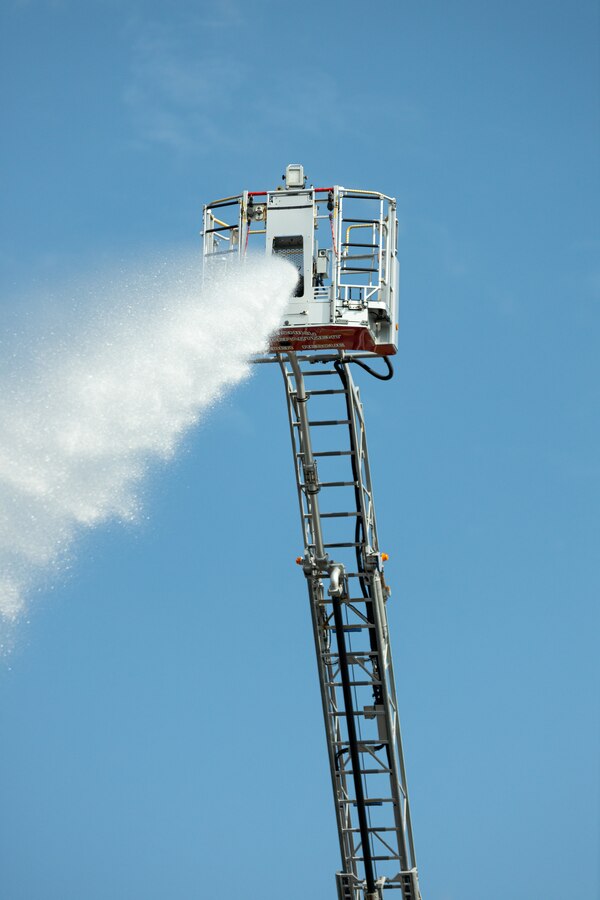 Firefighters with the Kinchiku Fire Department utilize a tower ladder to extinguish a simulated aircraft fire from above during an air mishap exercise on Camp Hansen, Okinawa, Japan, Feb. 9, 2023. The bilateral training exercise tasked all participants with extinguishing an aircraft fire, retrieving all simulated casualties, and treating any injuries to bolster response plans for aircraft mishaps. U.S. Forces Japan and the Okinawa Defense Bureau coordinated the exercise with Provost Marshal’s Office, the Camp Hansen Camp Guard, Marine Corps Installations Pacific, Fire and Emergency Services, surrounding area local fire departments, district police departments, and the U.S. Naval Hospital Okinawa. (U.S. Marine Corps photo by Lance Cpl. Thomas Sheng)