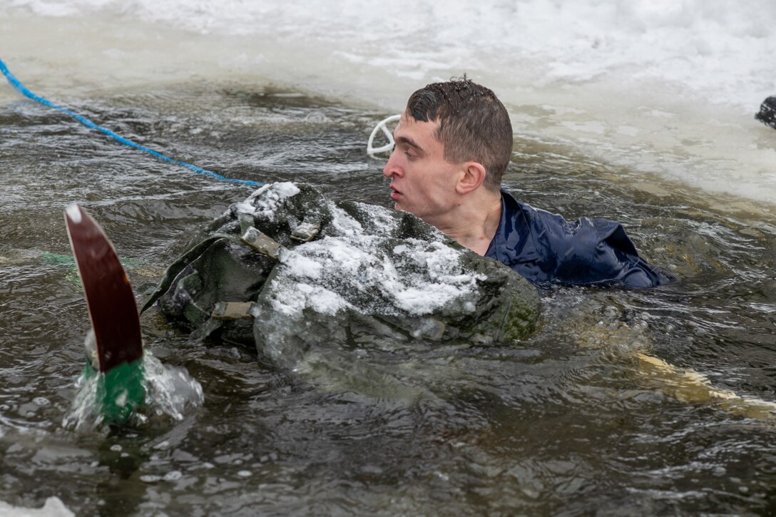 U.S. Army 1st Lt. Justice Norris assigned to Charlie Company, 1-24 Infantry Battalion, 11th Airborne Division, retrieves skiing gear during the polar plunge portion of winter survival training at Arctic Forge 2023 on Sodankylä Garrison, Finland, Feb 19, 2023.