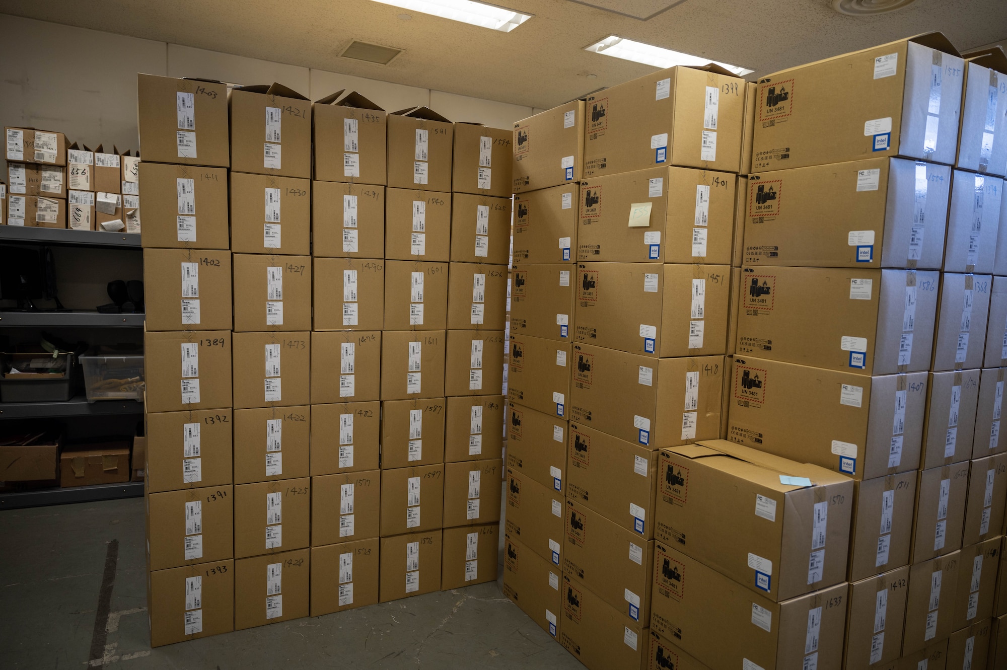 Boxes of computers are stored in a room.