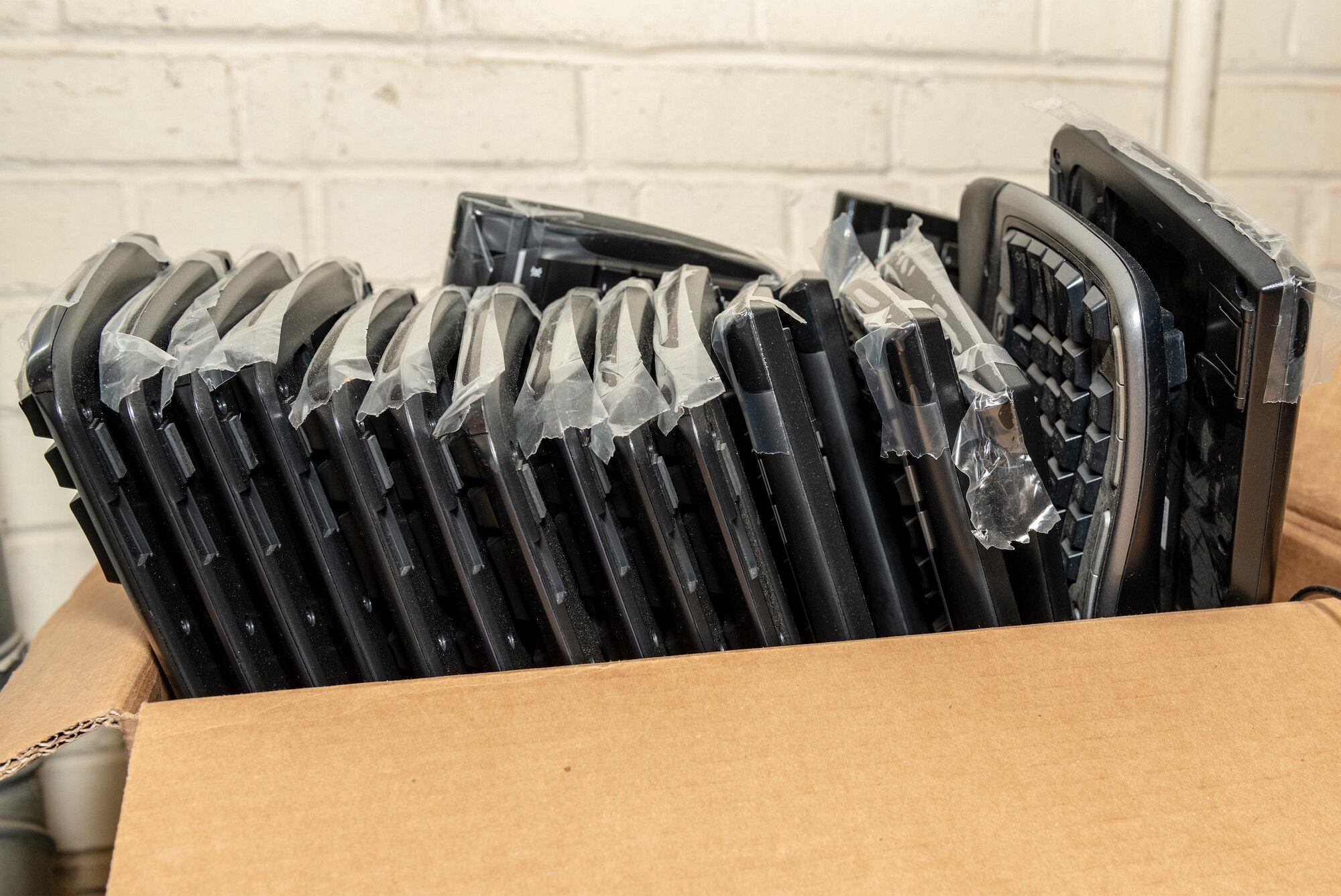 Computer keyboards are stored in a box.