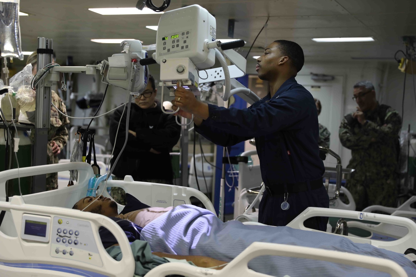 NORFOLK, Va. (Feb. 16, 2023) Hospital Corpsman 3rd Class Devon Fontenot (right) and Hospital Corpsman 2nd Class Stephanie Fallon, both assigned to the wasp-class amphibious assault ship USS Bataan (LHD 5) Medical Department, perform a simulated x-ray on Hospital Corpsman 2nd Class Farrie Jalin as part of a pier-side trauma training exercise, Feb. 16, 2023. The medical exercise was conducted as part of a Naval Medical Forces Atlantic and U.S. Fleet Forces Command-driven effort to align with and support fleet and joint requirements, and to improve deployment readiness of organic fleet medical departments. During the evolution, the ship’s medical staff participated in several medical scenarios and received real-time feedback in order to build enhanced knowledge and skillsets. (U.S. Navy photo by Mass Communication Specialist 2nd Class Darren Newell)