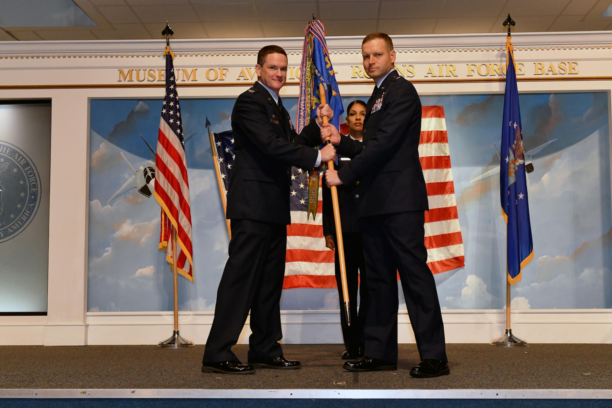 Two men holding guidon