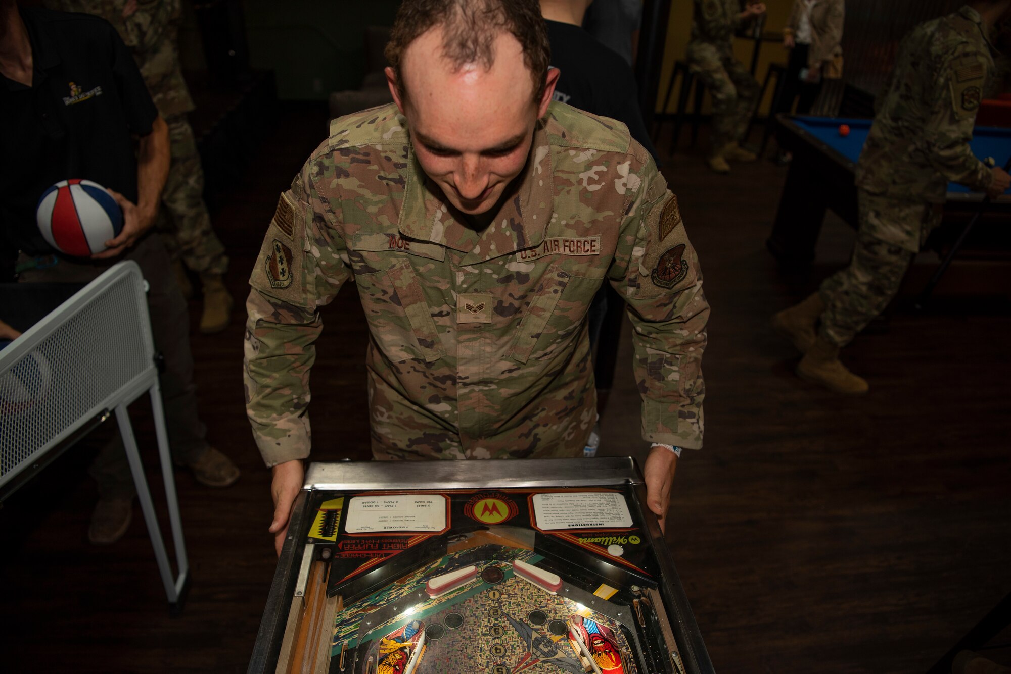 Senior Airman Crayton Noe, 7th Bomb Wing religious affairs Airman, plays a pinball game inside the Soul Fire Café at Dyess Air Force Base, Texas, June 3, 2022. The Soul Fire Café offers Airmen coffee, music, shuffleboard, massage chairs, a pool table, air hockey and arcade games. (U.S. Air Force photo by Airman 1st Class Ryan Hayman)