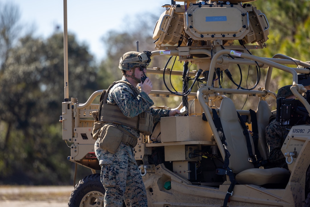 U.S. Marine Corps Cpl. Beau Arsenault, a low altitude air defense (LAAD) gunner with 2d LAAD Battalion on Marine Corps Air Station Cherry Point, communicates the operations of the Light Marine Air-Defense Integrated System (LMADIS) to the unmanned aerial vehicle pilots during a pre-deployment training at Marine Corps Outlying Landing Field Atlantic, North Carolina, Feb. 15, 2023. The training allowed Marines to be hands-on with the LMADIS in preparation for a future deployment with a Marine Expeditionary Unit. (U.S. Marine Corps photo by Lance Cpl. Matthew Williams)