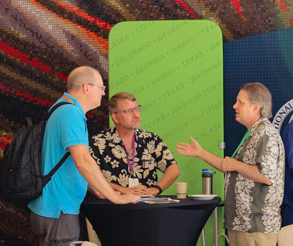 CSD Technical Director Neal Ziring, right, and Research Liaison John Ziegler, center, engage with a conference attendee during this year’s NSA-sponsored Hawaii International Conference on System Sciences in Maui, Hawaii