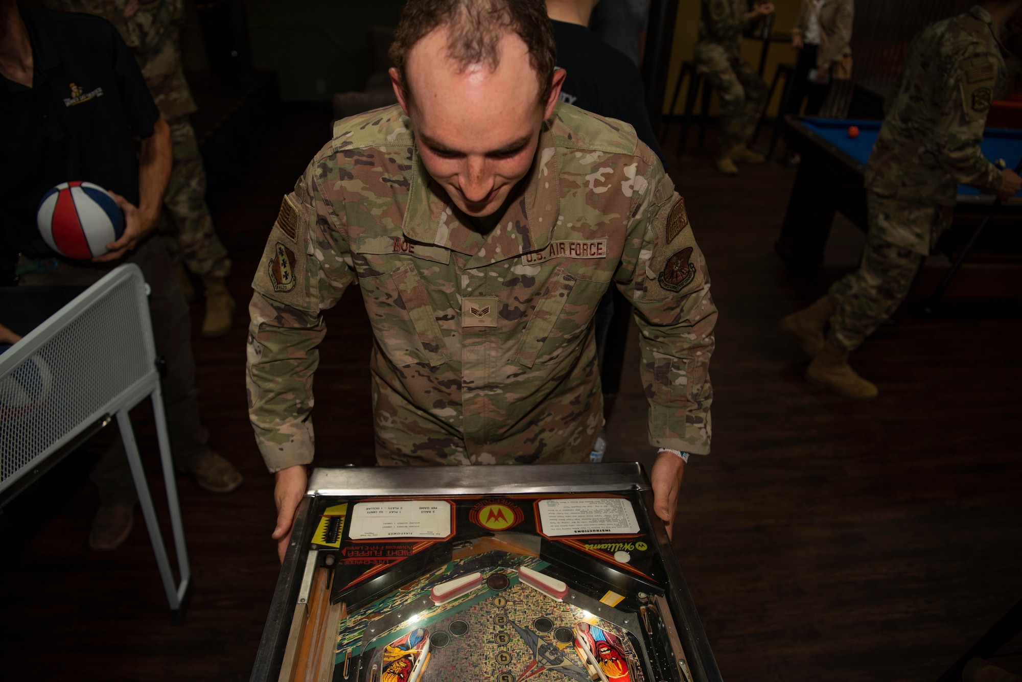 Senior Airman Crayton Noe, 7th Bomb Wing religious affairs Airman, plays a pinball game inside the Soul Fire Café at Dyess Air Force Base, Texas, June 3, 2022. The Soul Fire Café offers Airmen coffee, music, shuffleboard, massage chairs, a pool table, air hockey and arcade games. (U.S. Air Force photo by Airman 1st Class Ryan Hayman)