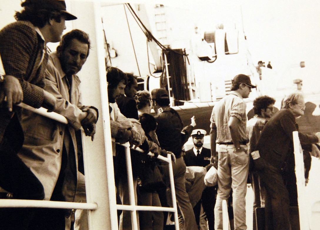 Persian Gulf, Evacuees from Iran relax as they wait for processing on USS La Salle (AGF-3). About 267 people departed Bandar Abbas, Iran, on British survey ships which transferred them to La Salle in international waters. About 130 of the evacuees are U.S. citizens Photographed by JO1 Tim Lewis/PH2 J. F. Bishop, February 22, 1979. Official U.S. Navy Photograph, now in the collections of the National Archives.