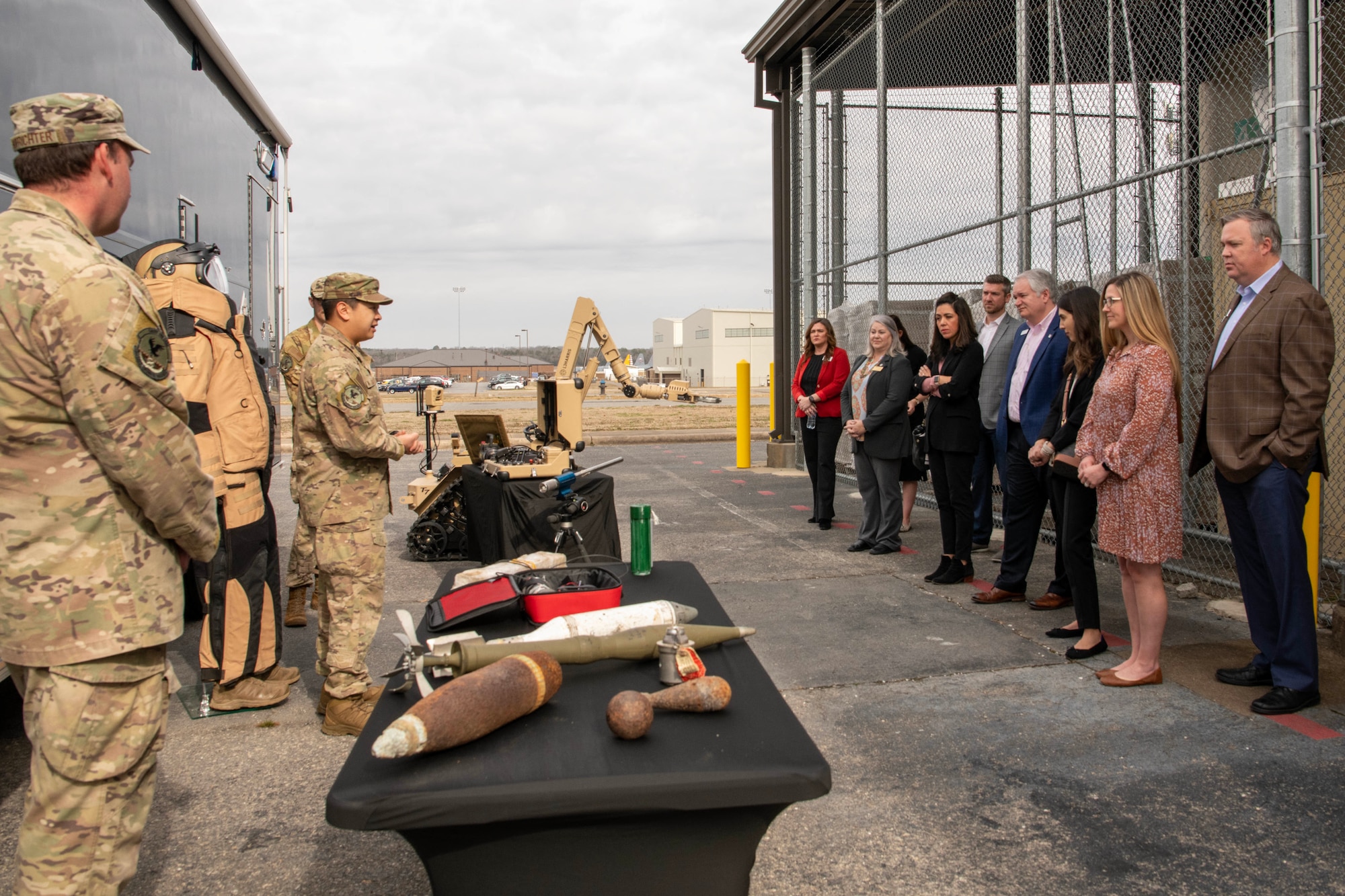 Military members on the left brief a group of civic leaders on the right.