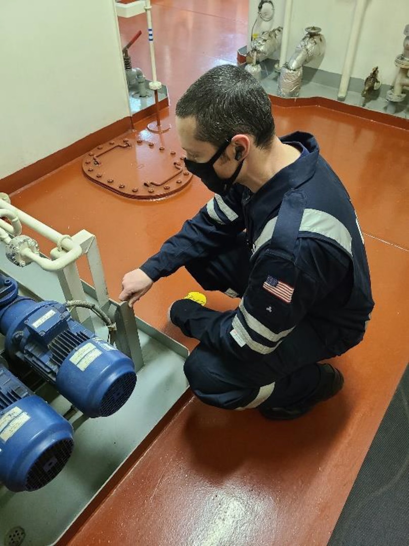 Petty Officer 1st Class Bradley Martin, a marine science technician, wears enhanced hearing protection while conducting an exam in a high-decibel environment on a ship in Boston in January 2022. The Coast Guard continues to evaluate these electronic earbuds as a safety measure, using seed funding and resources from the Science and Technology Innovation Center (STIC). (Coast Guard photo)