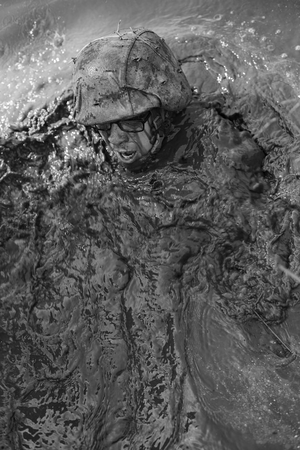 A candidate conducts the Combat Course. The Combat Course provides an austere environment littered with obstacles in which the candidates must negotiate with their fire team. The tactical skills emphasized include the use of cover and concealment, fire team movement, and security. (U.S. Marine Corps photo by Sgt Gumchol Cho)